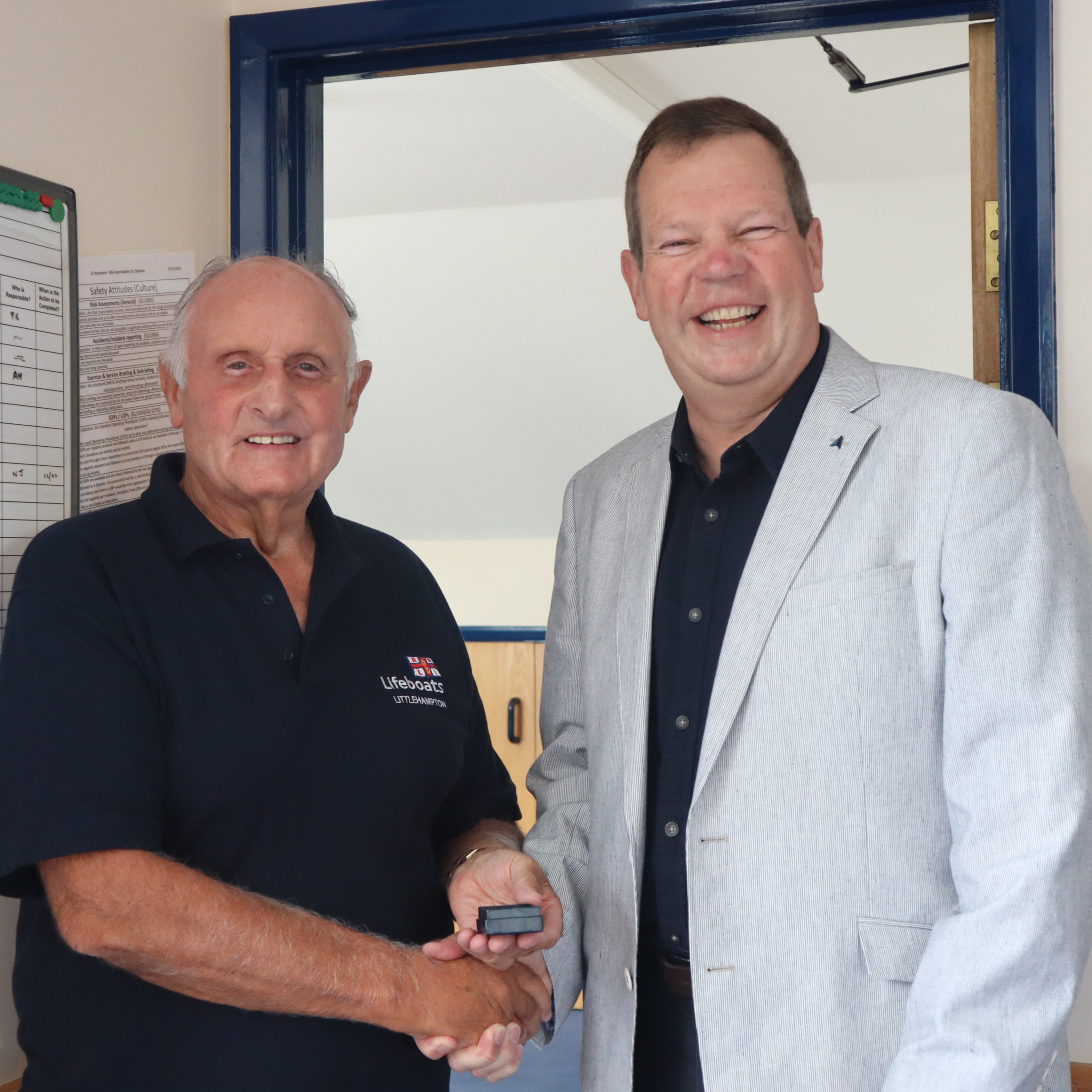 Geoff Warminger (left) receives his 50 year service medal from Mike McCartain (right)