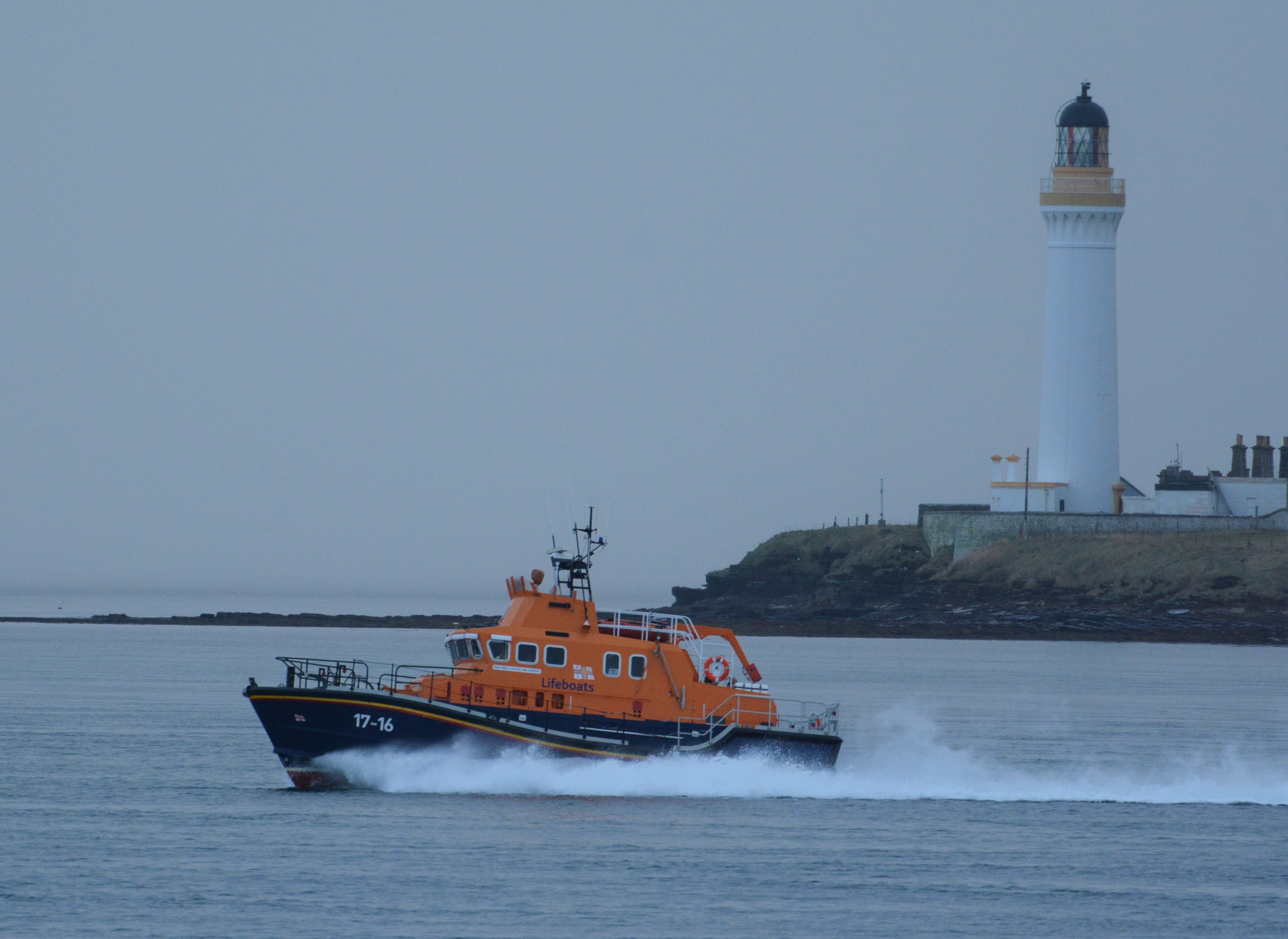 The lifeboat at full speed passing Hoy High Lighthouse, Graemsay, Orkney