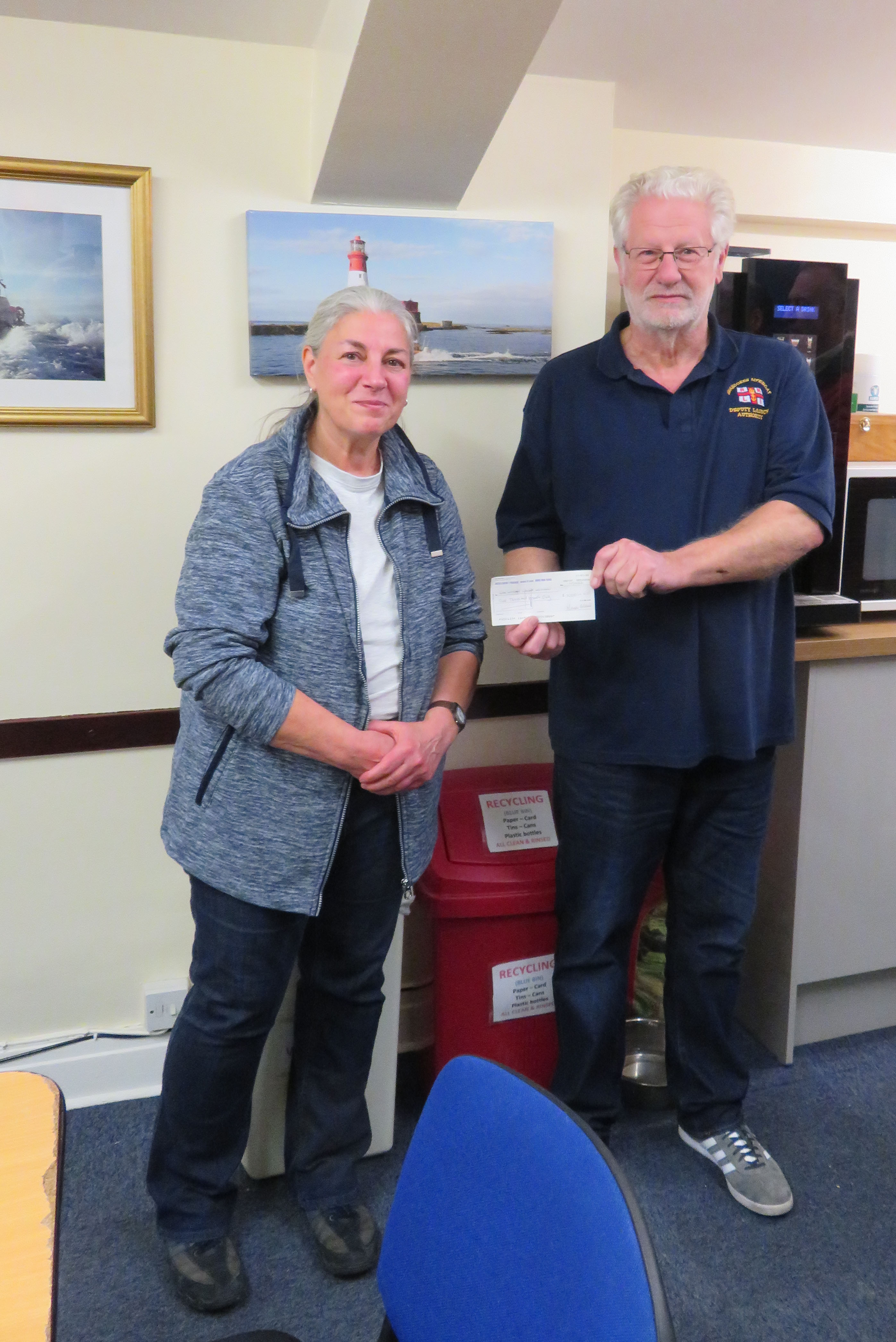 Acting Lifeboat Operations Manager Colin Banks accepts a cheque for £1000 from Karen Black of Skipton Divers