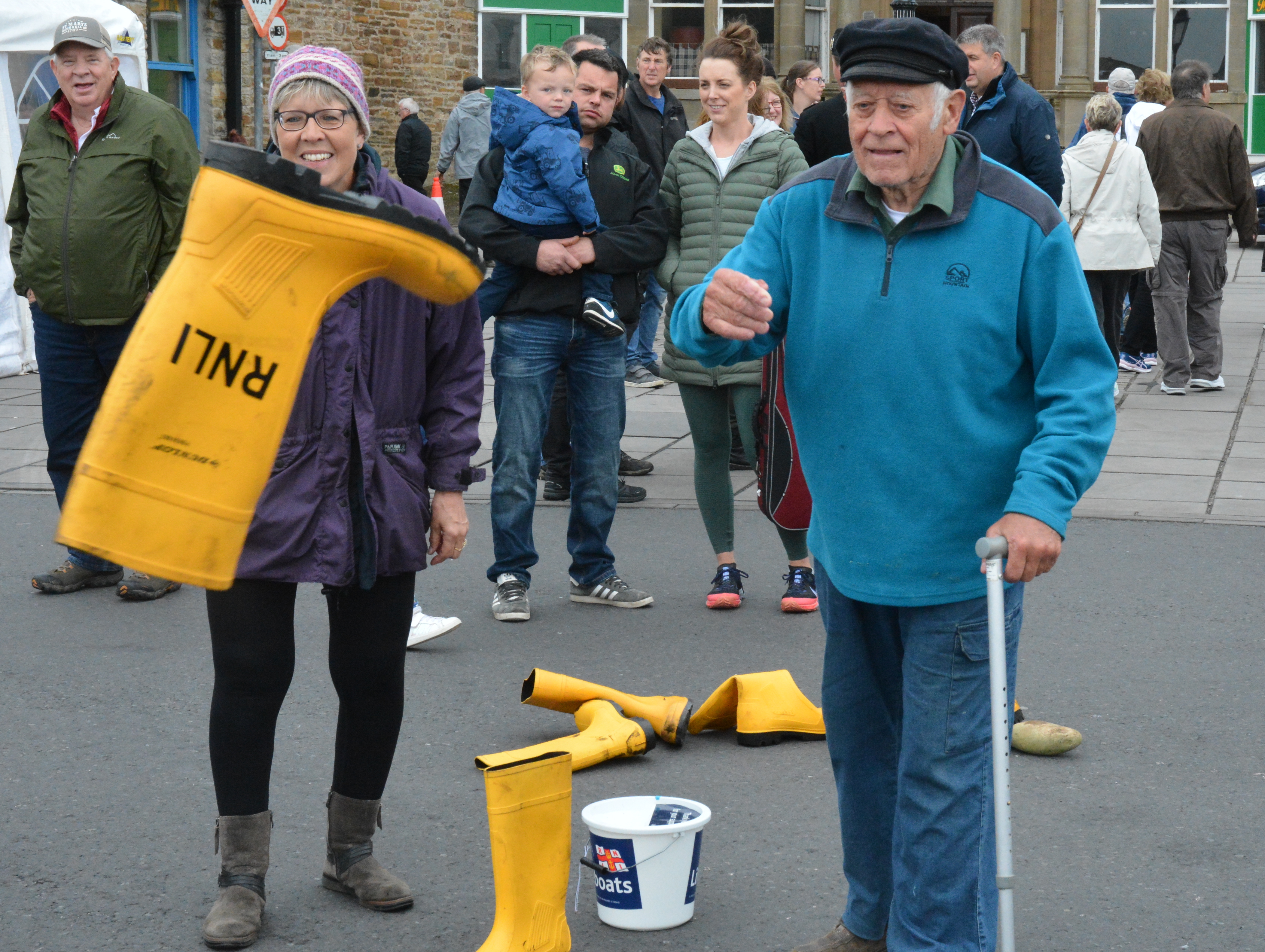 Gentleman throws a RNLI welly into a tub to win a prize