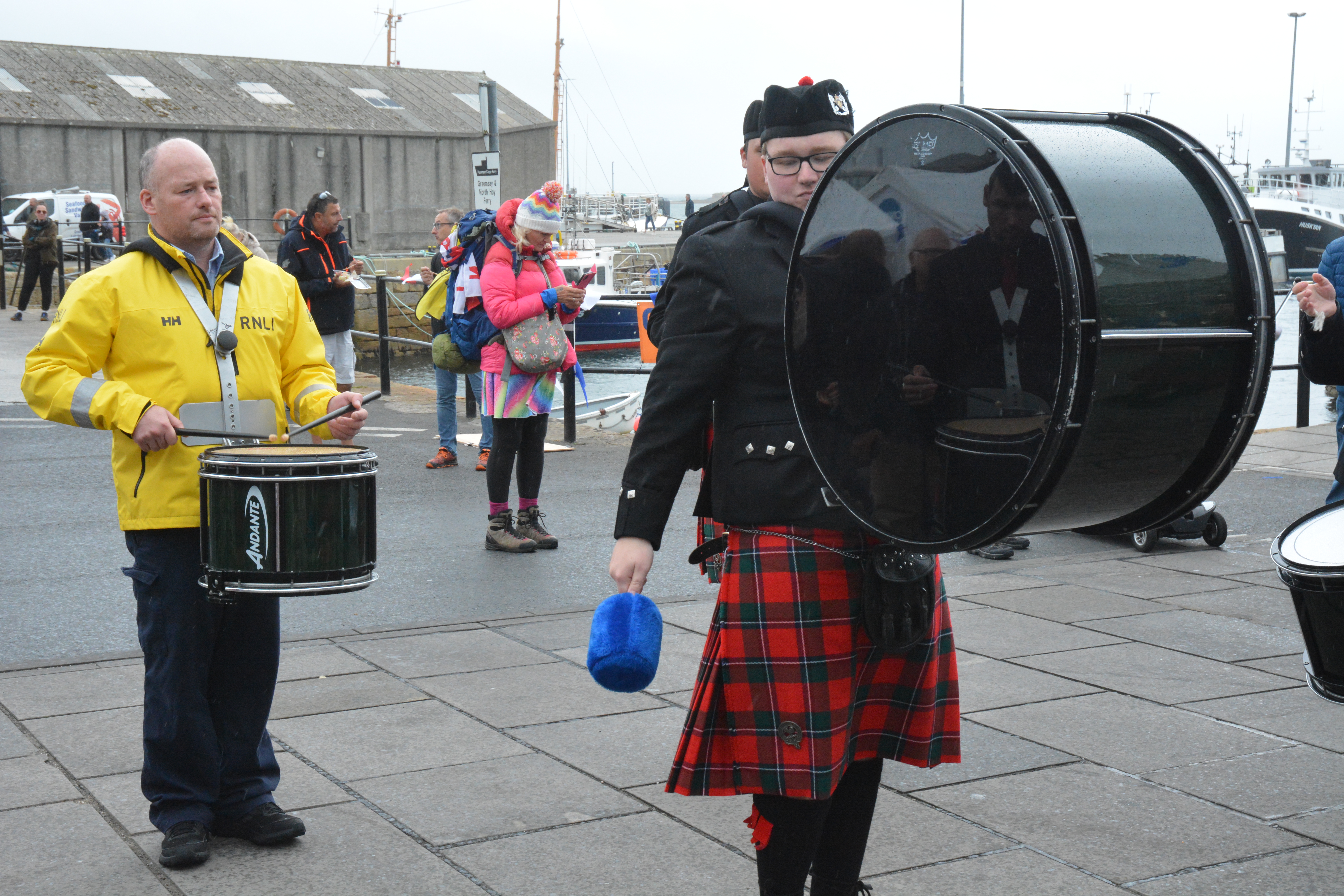 Crew member and Pipe Band member plays drum in his RNLI kit.