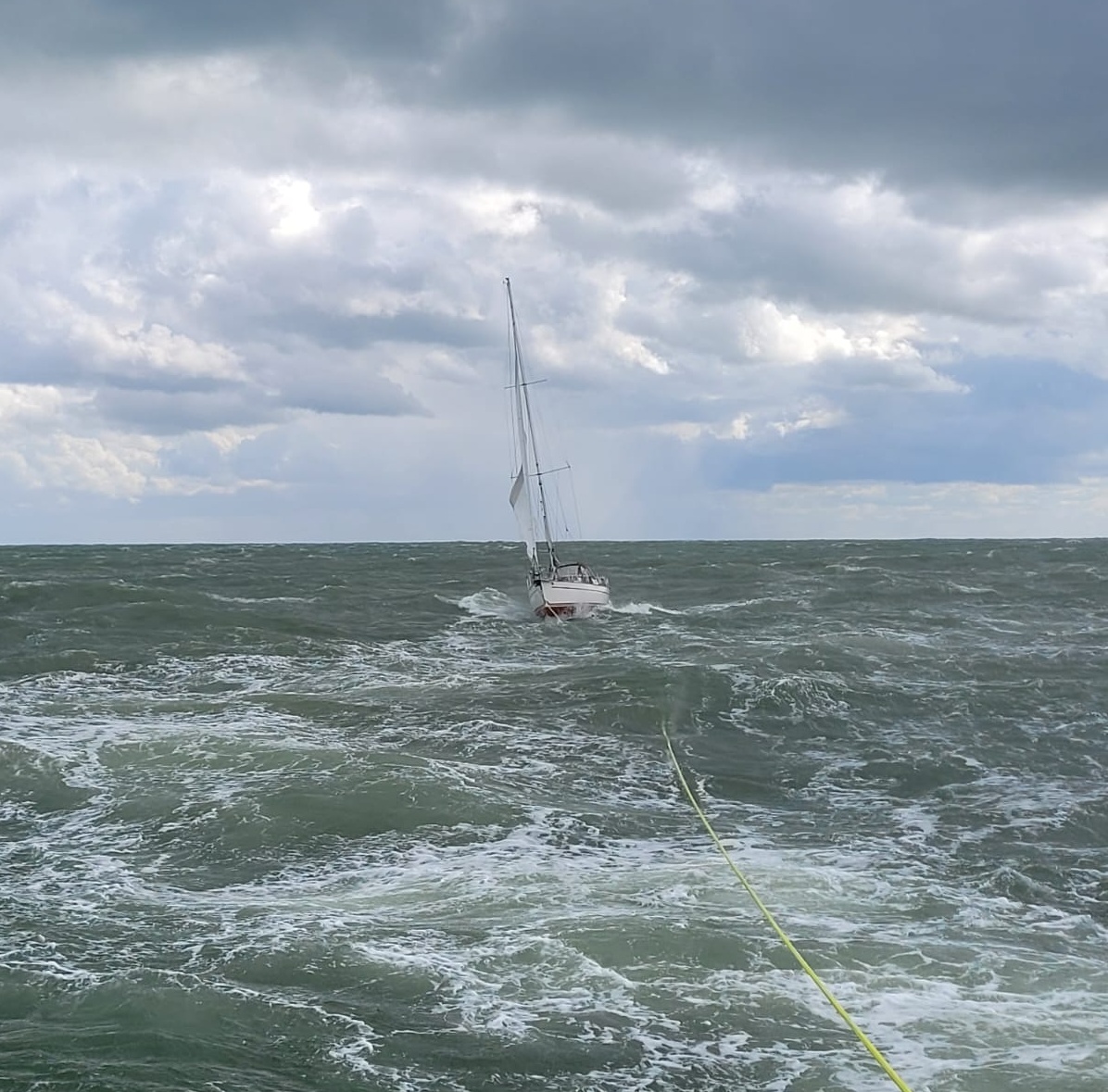 Yacht being towed in rought seas.