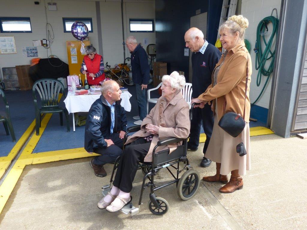 Kathy in a wheelchair with people around her. 