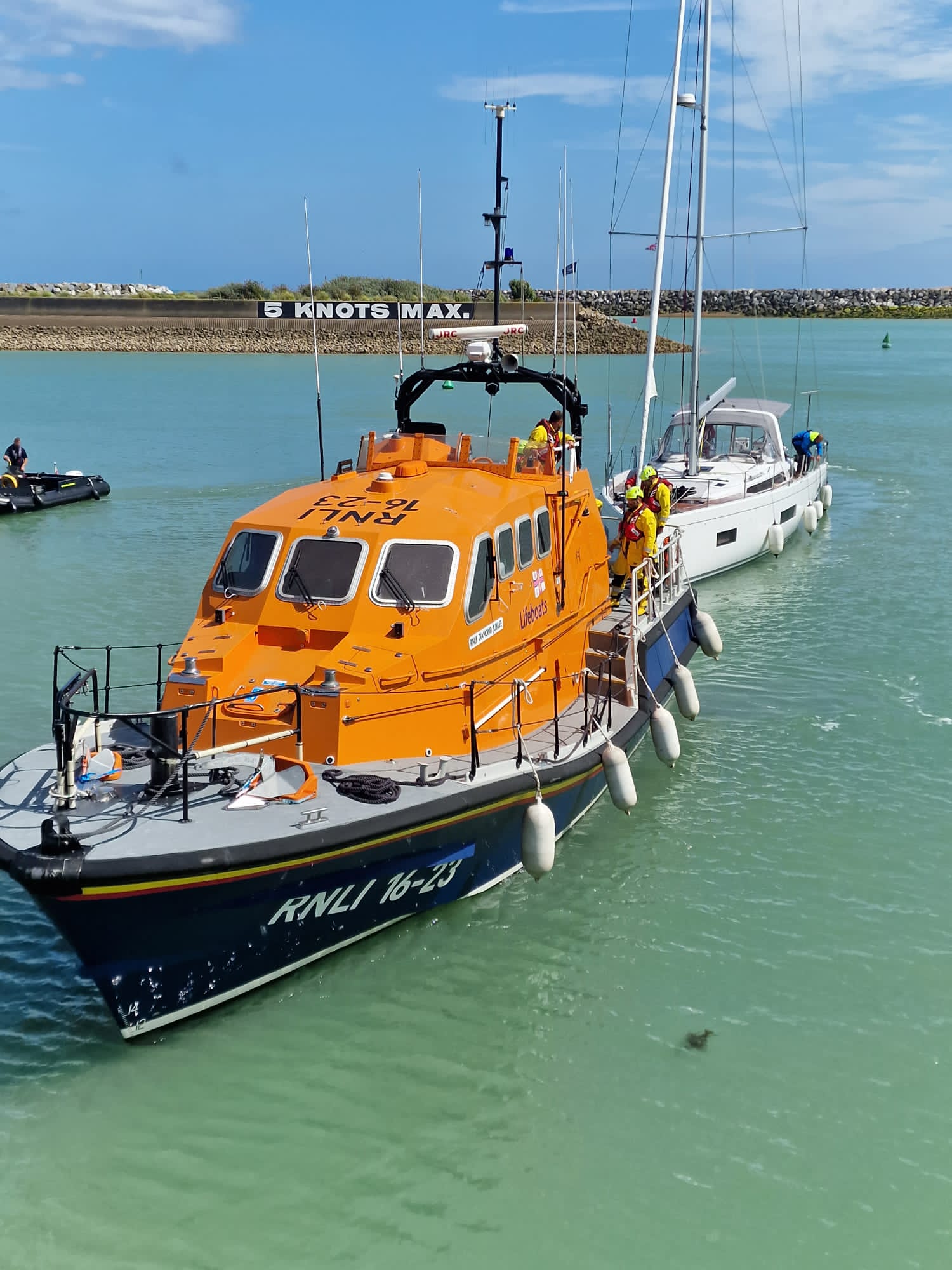 Lifeboat entering lock with yacht behind it