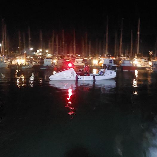 The white specially made rowing boat in Maryport harbour at night 