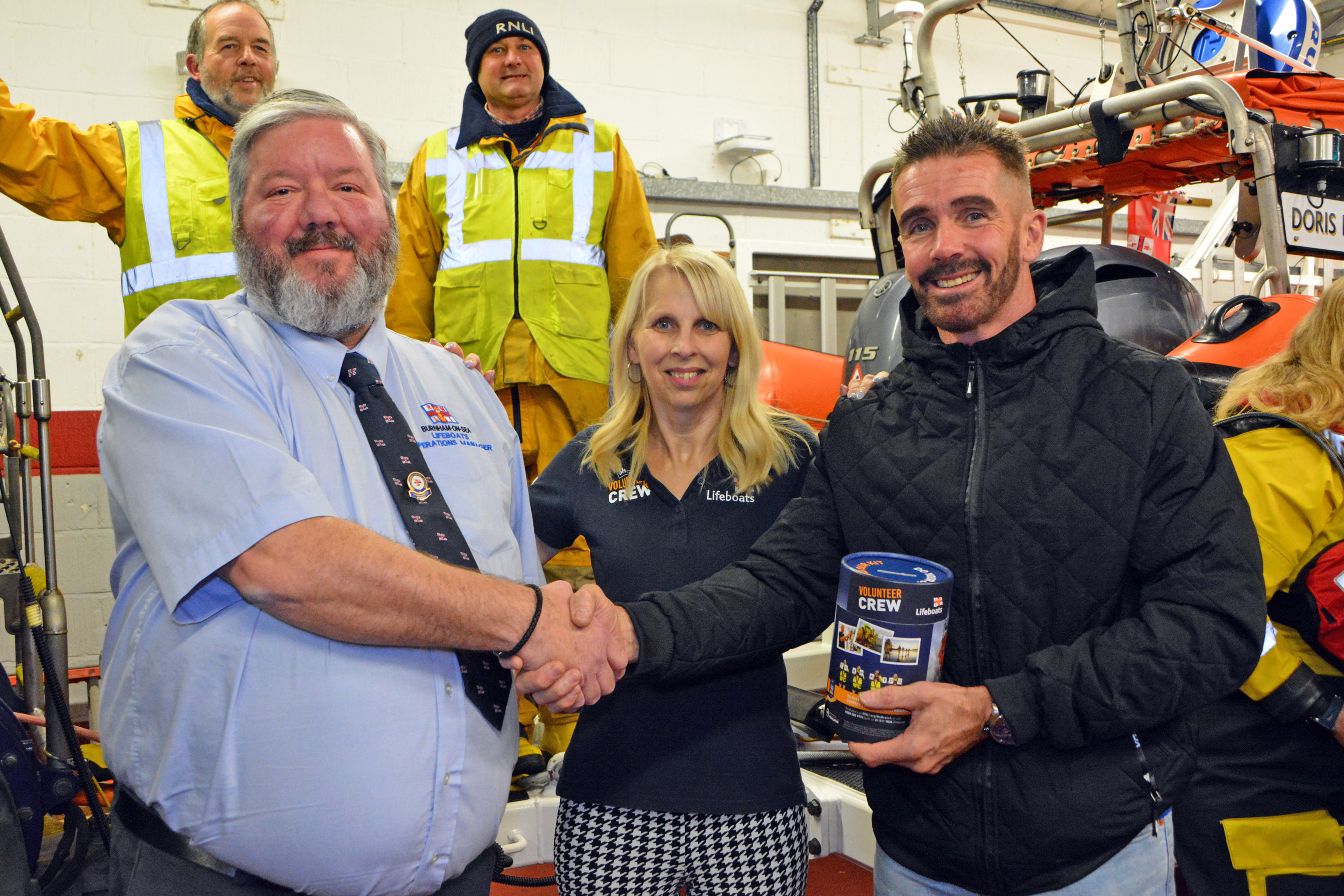 Burnham Lifeboat Operations Manager Matt Davies receives the donation from Sarah and Wayne