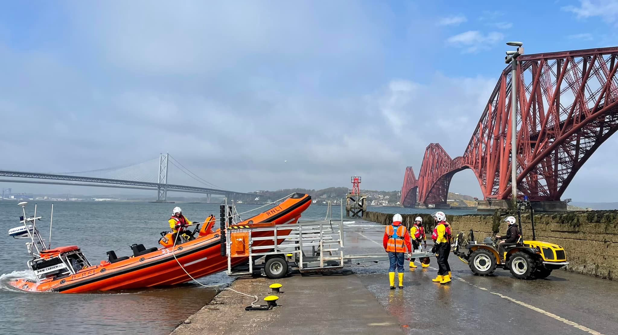 Queensferry RNLI Lifeboat launching on service, from the Hawes Pier. The lifeboat is 'tipped in' backwards off the carriage.