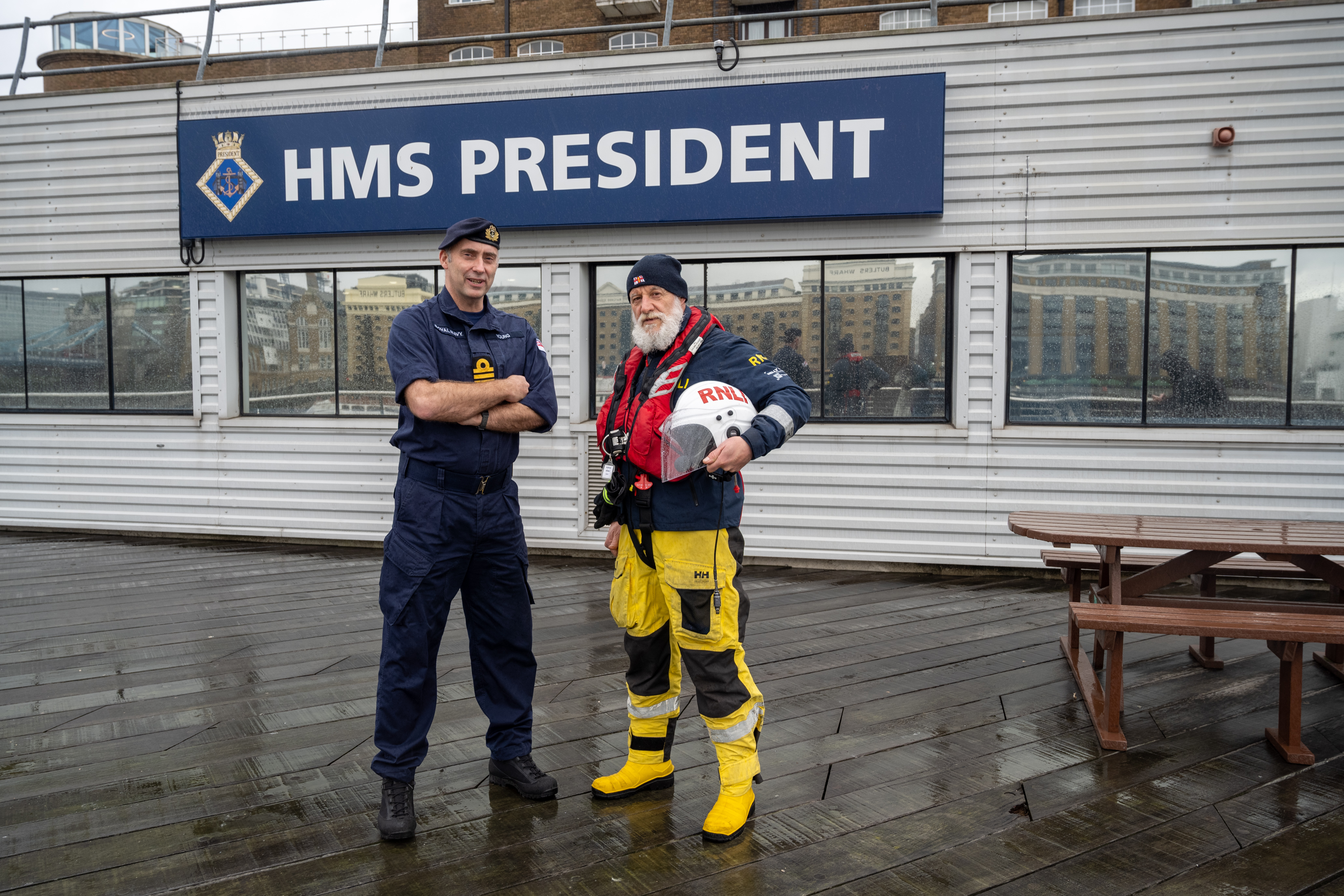 Two representatives from the RNLI and HMS President appear stood outside the building.