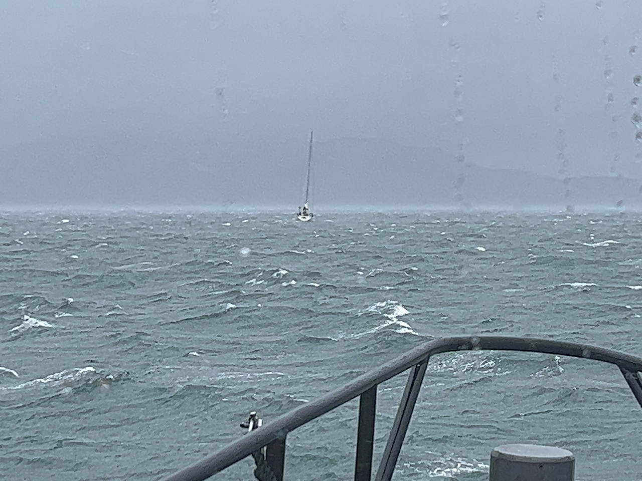 Yacht in distance in stormy sea