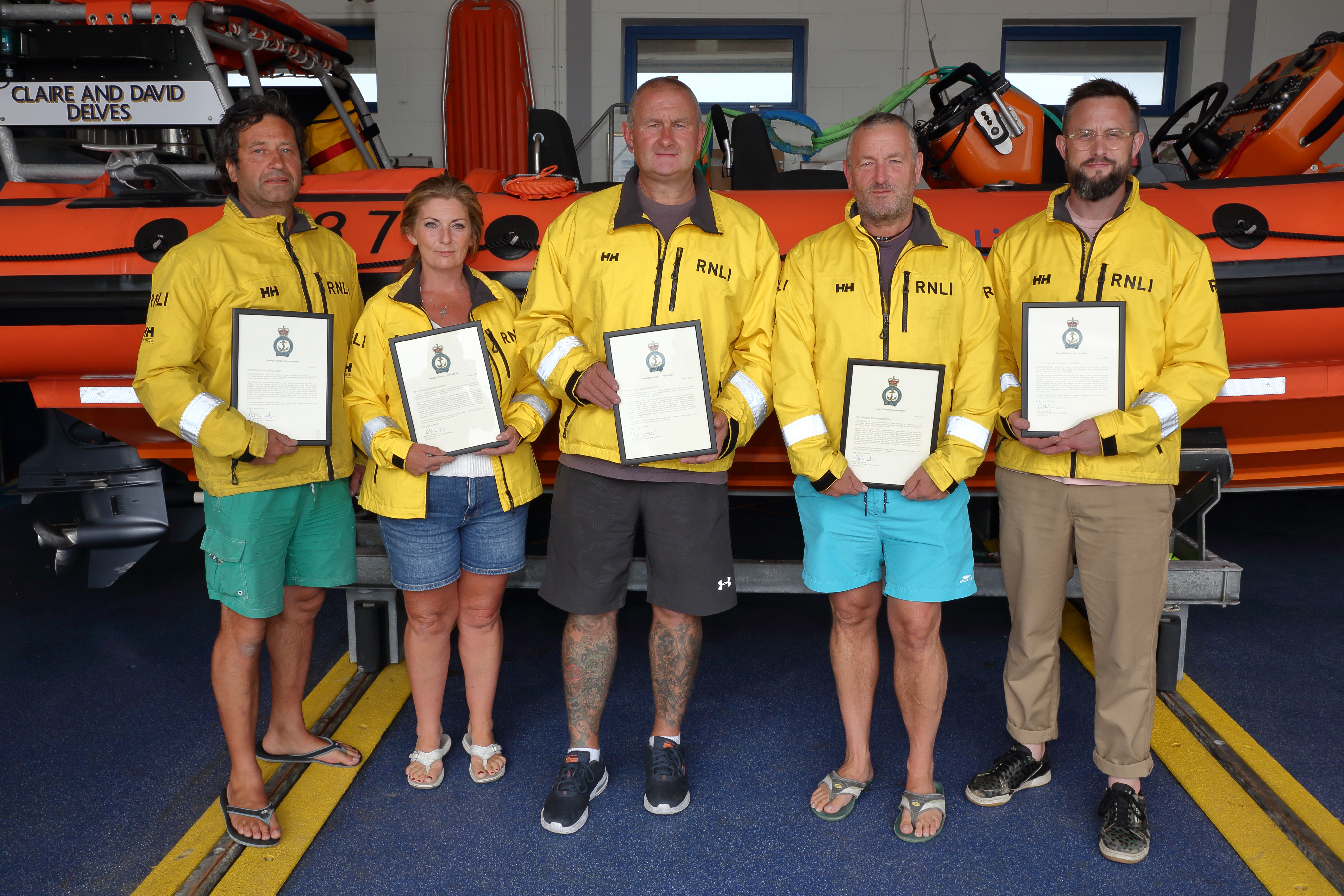 Five crew members holding their certificates