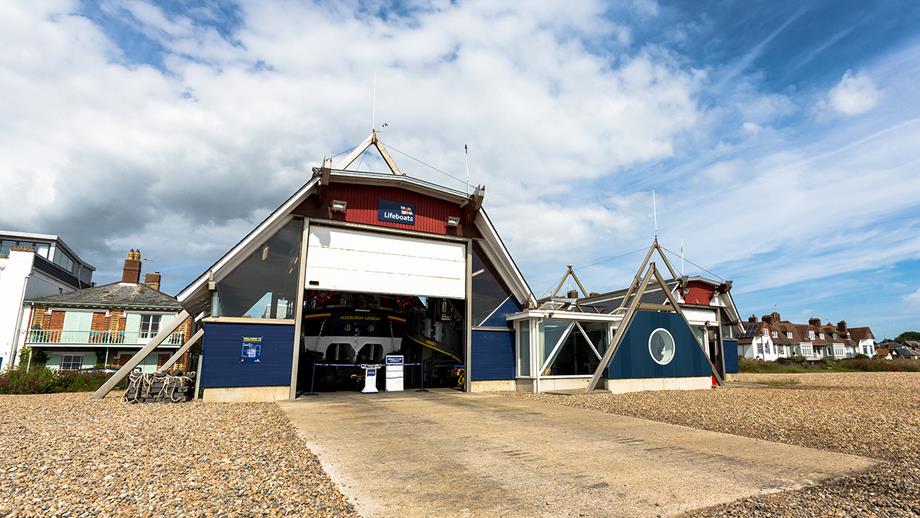 Picture shows Aldeburgh Lifeboat Station from the beach with the roller shutter door open against a blue sky