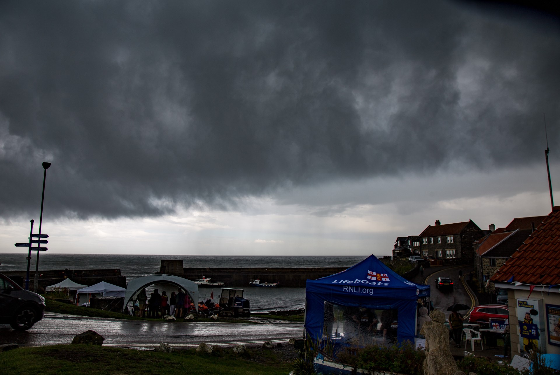 Dark rain clouds over the harbour before the start of the fete