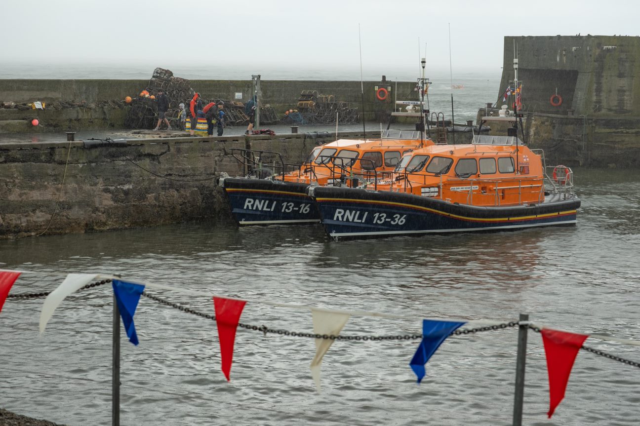 Both Shannon class lifeboats moored against the North pier at Craster Harbour