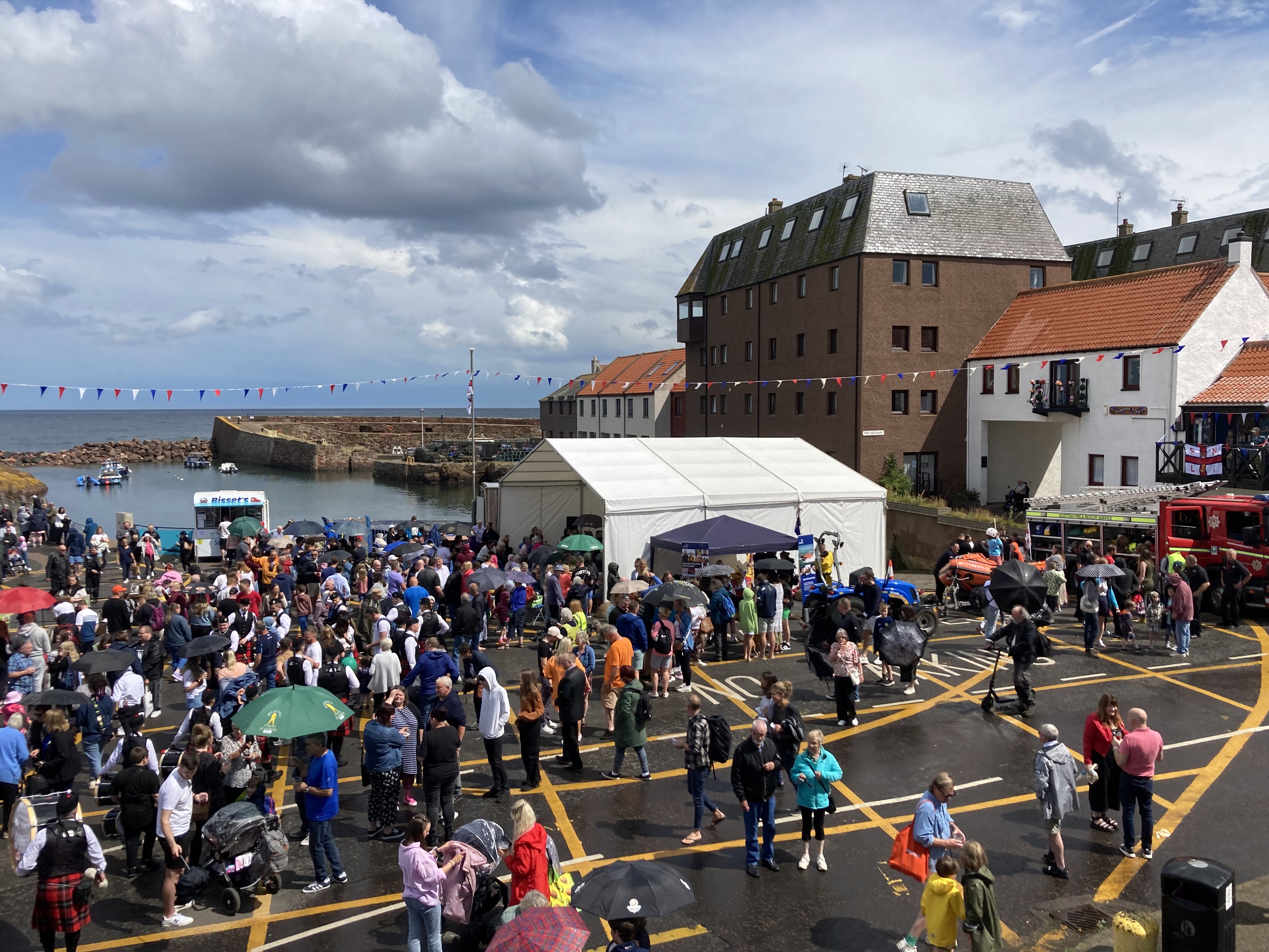 A photo of Dunbar Harbour showing the stage and inshore lifeboat on display.