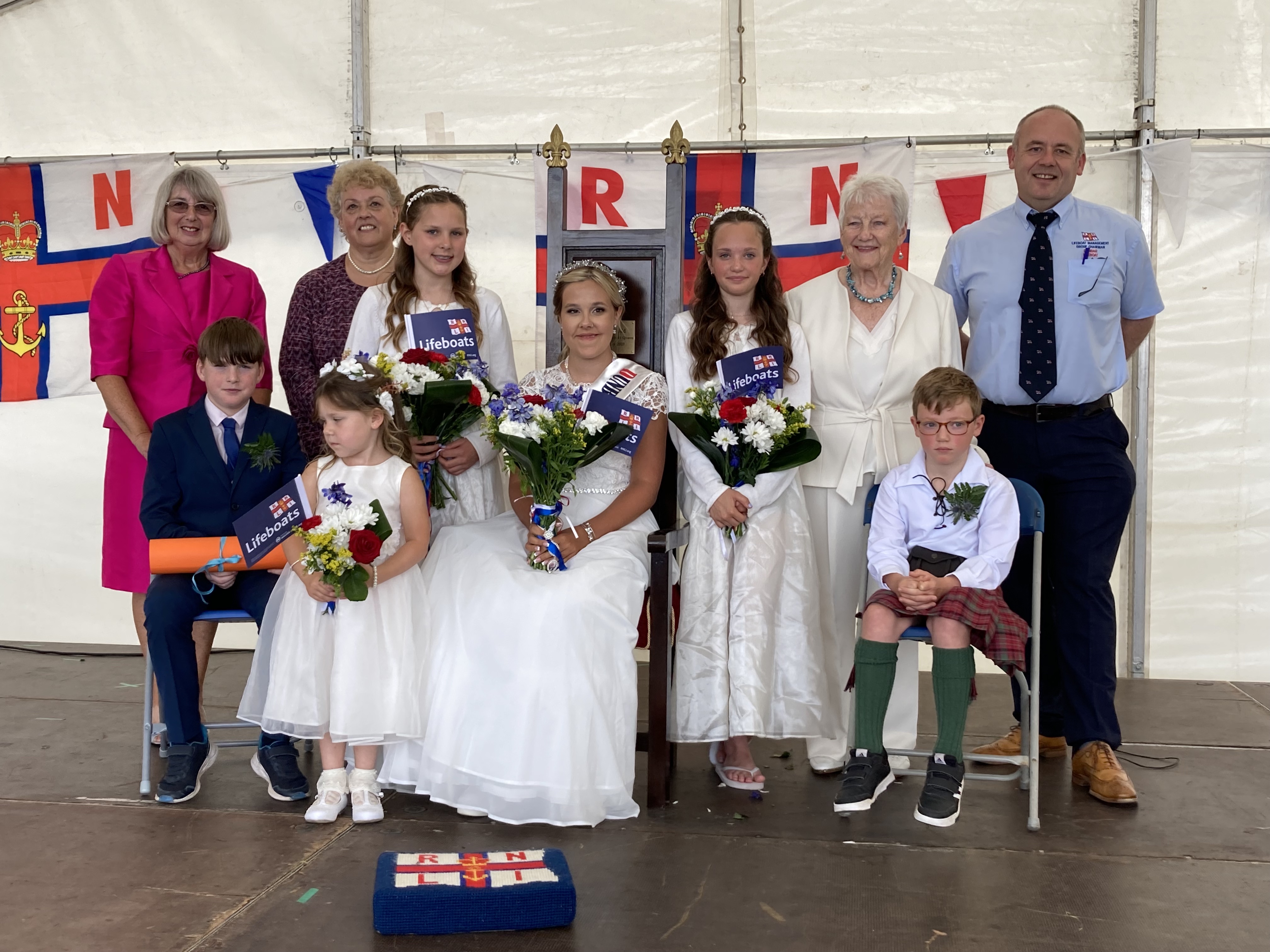 Our photo shows (L-R) Moira Porter, Murdo Ross, page boy, fundraising chair Veronica Davies, flower girl Zara Anderson, attendant Mirren Ross, Lifeboat Queen Emily Hodd, attendant Erin Forrester, Sheon Cairns, herald Lochlan Forrester, Mark Lees, LMG chair.