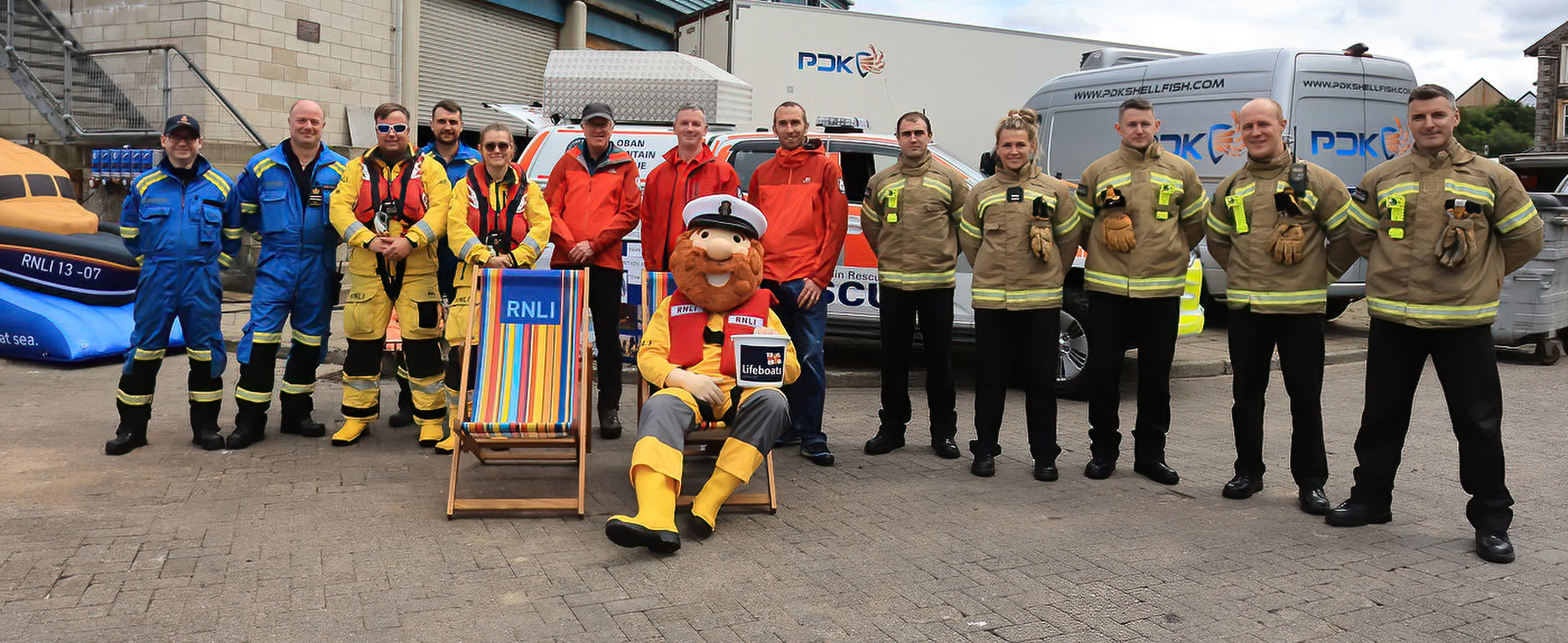 A posed photograph with mascot Stormy Stan and representatives of the Coastguard and Mountain Rescue teams and the fire service.