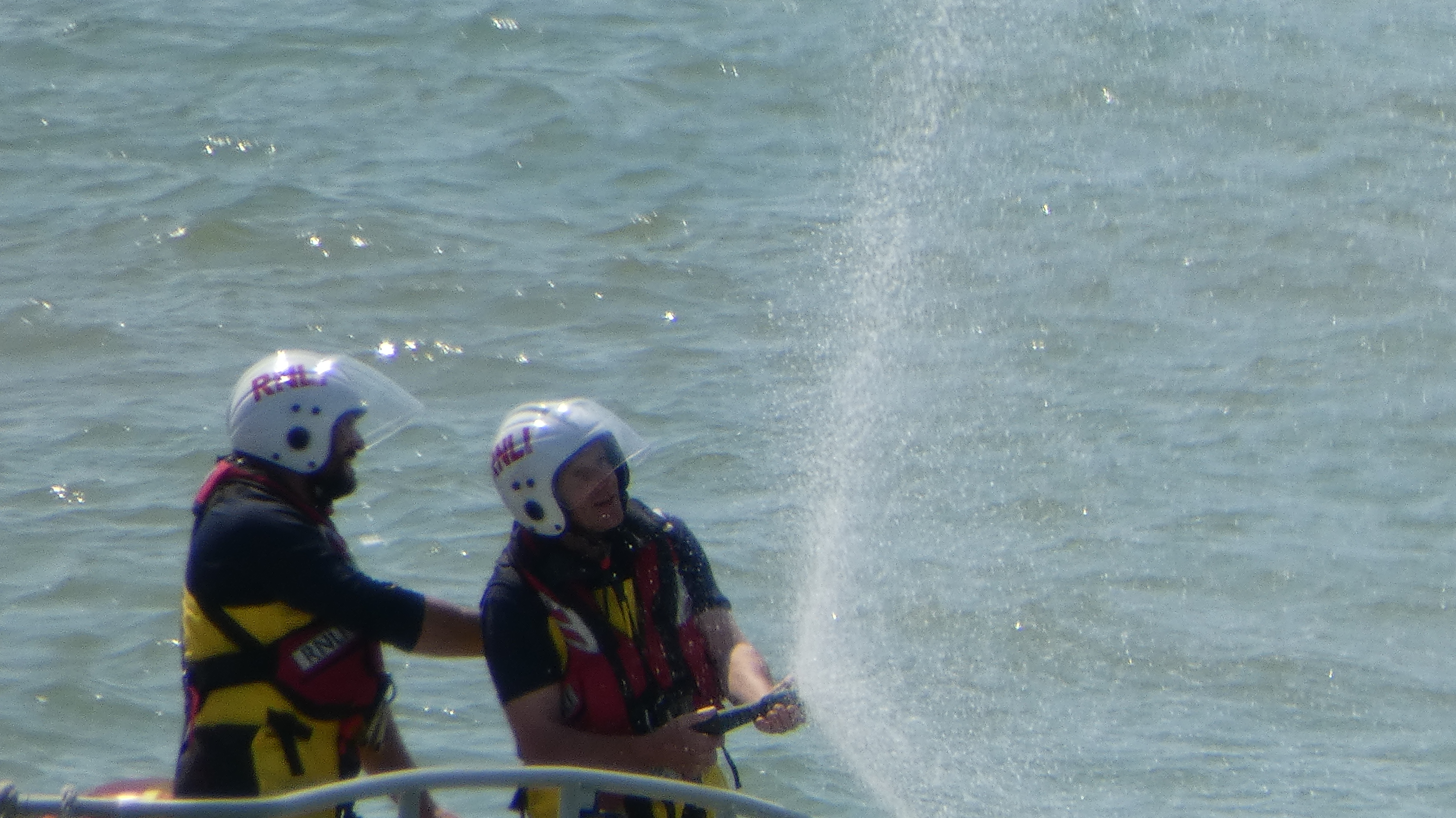 Crew members using a hose