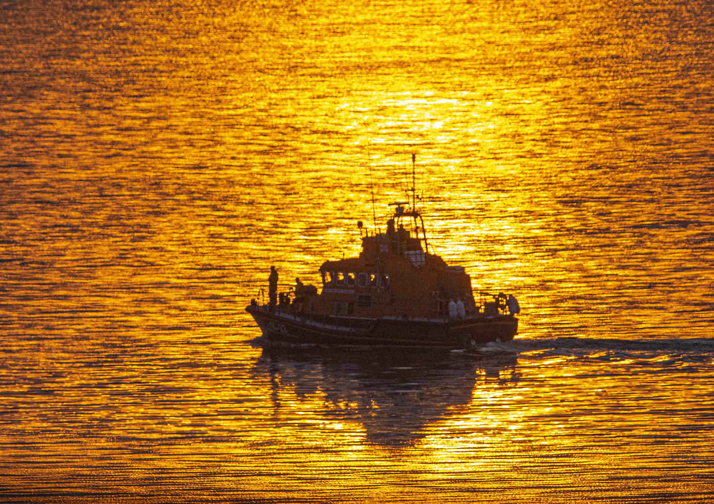 Library Photo of The Mora Edith MacDonald at sea off Oban in late summer sunshine with the waters around her a mix of yellows and golds.