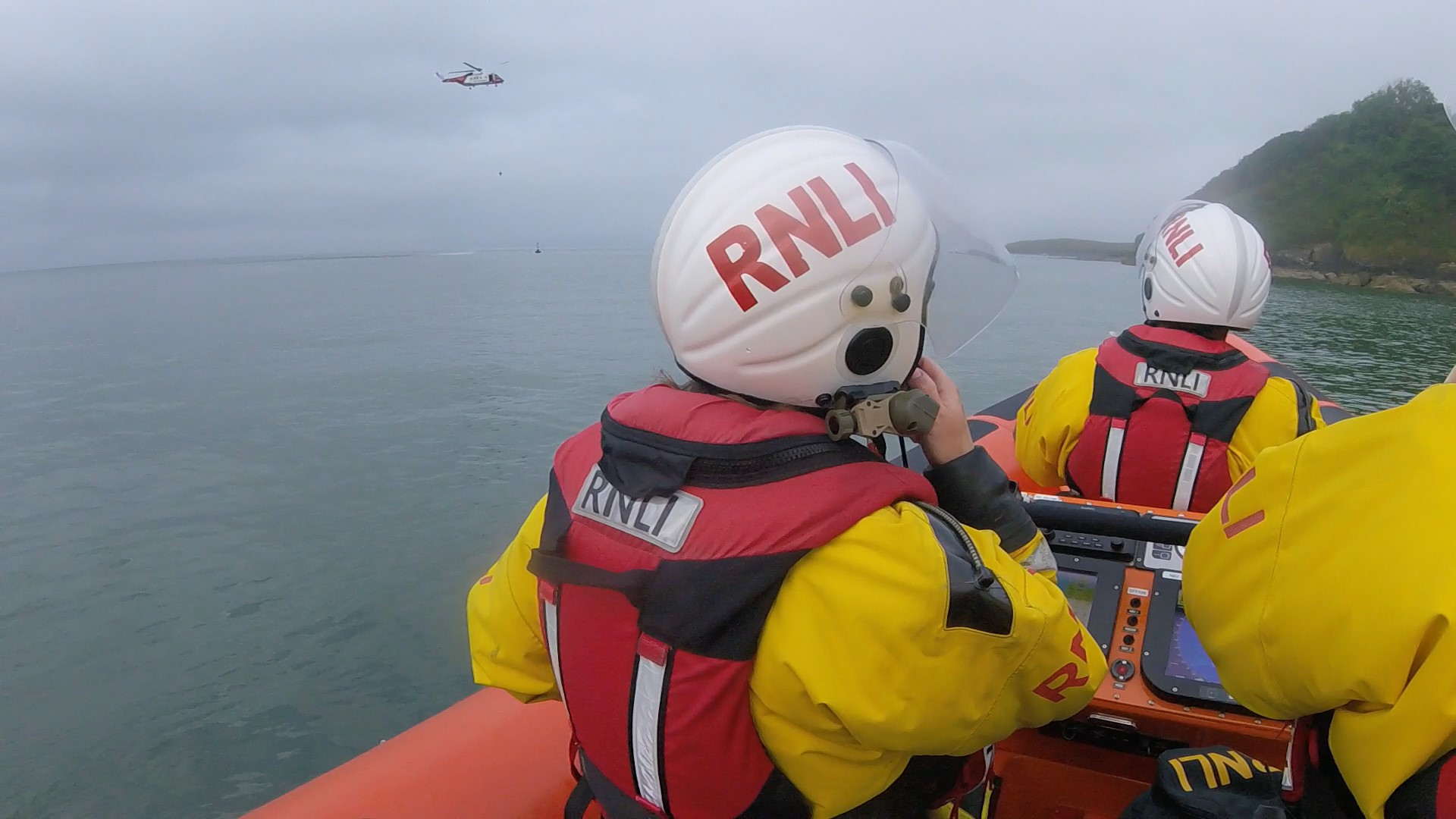 Falmouth inshore lifeboat standing by while the Coastguard search and rescue helicopter attempts to rescue the casualty