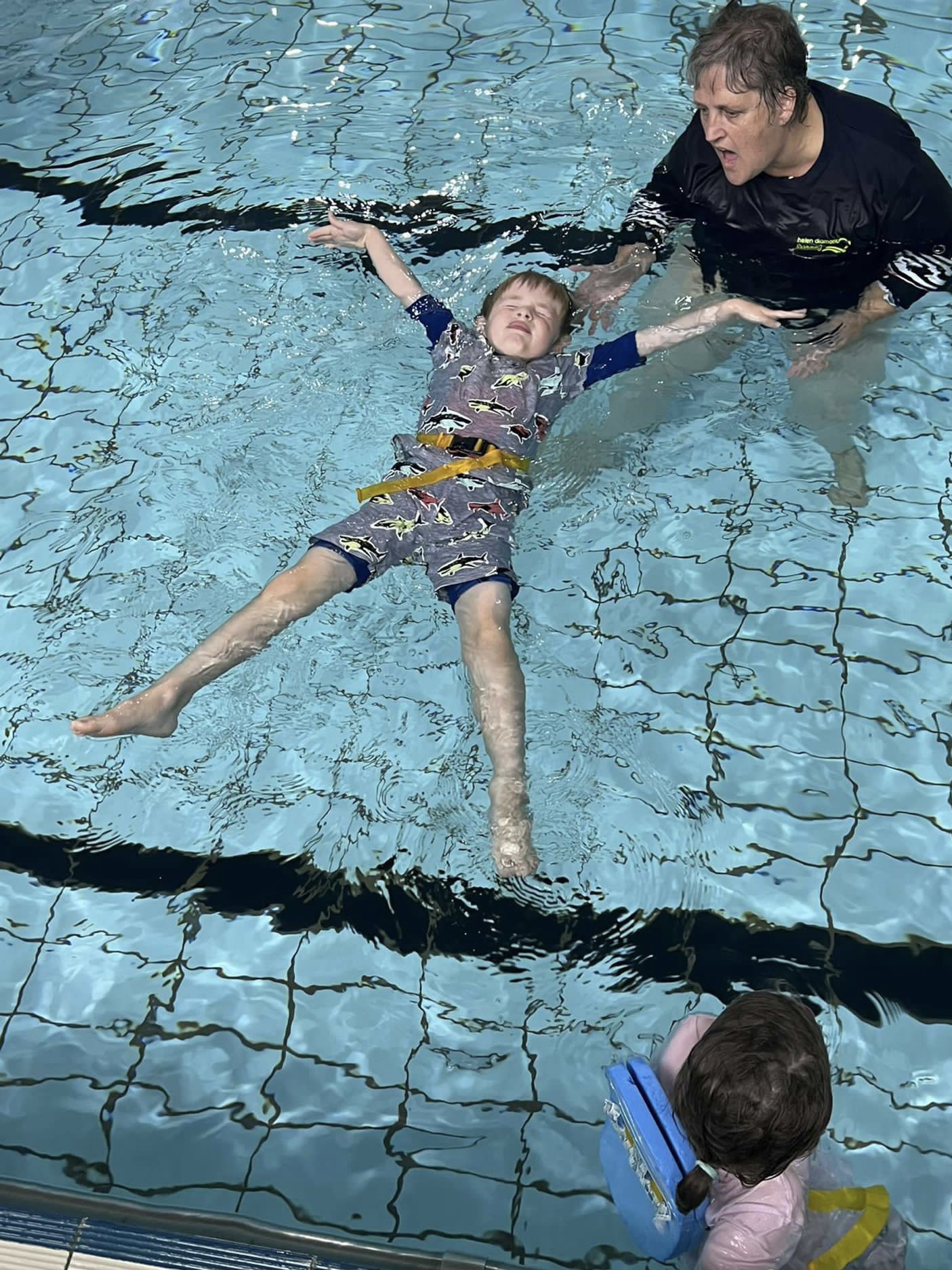 Young swimmer learning how to float ahead of Summer