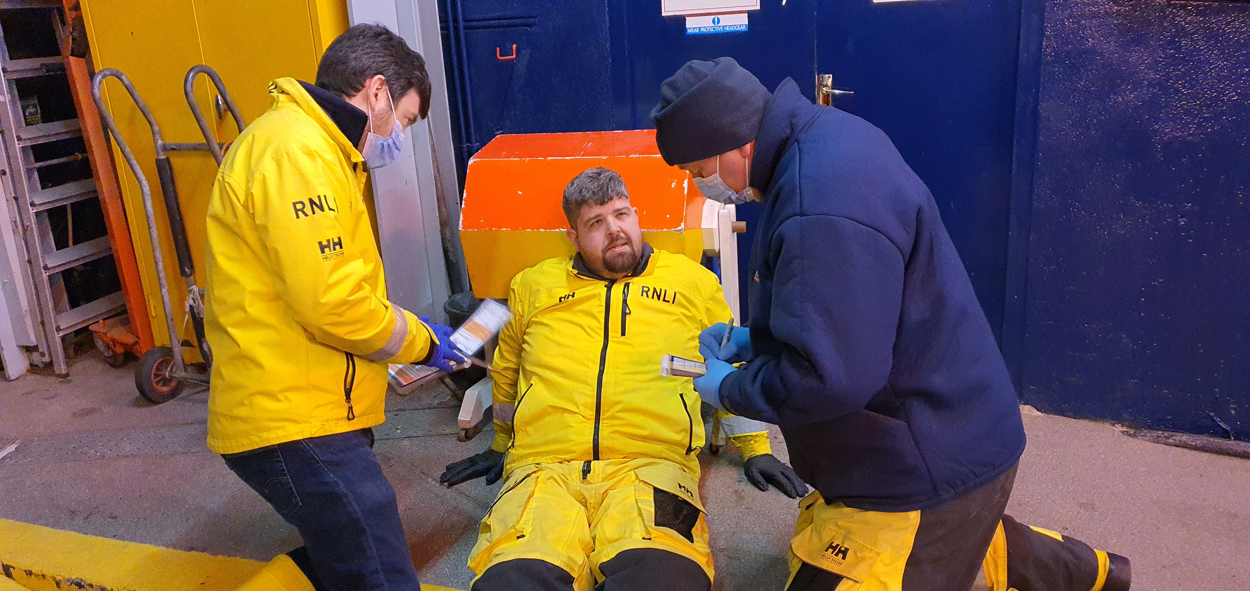 Two crew members carrying out an assesment of a casualty