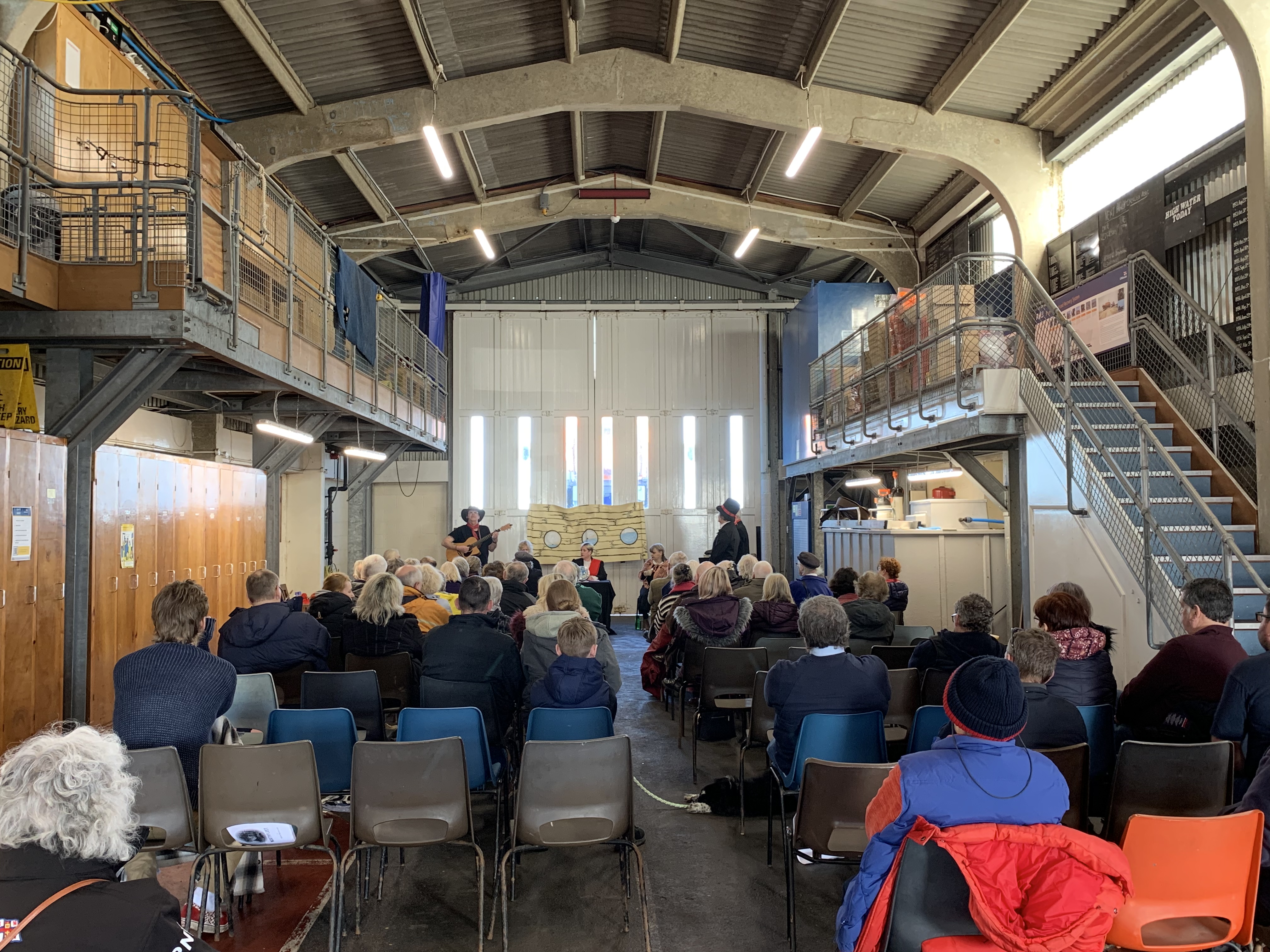 The crowd watching the performance unfold in the Dungeness RNLI boathouse.
