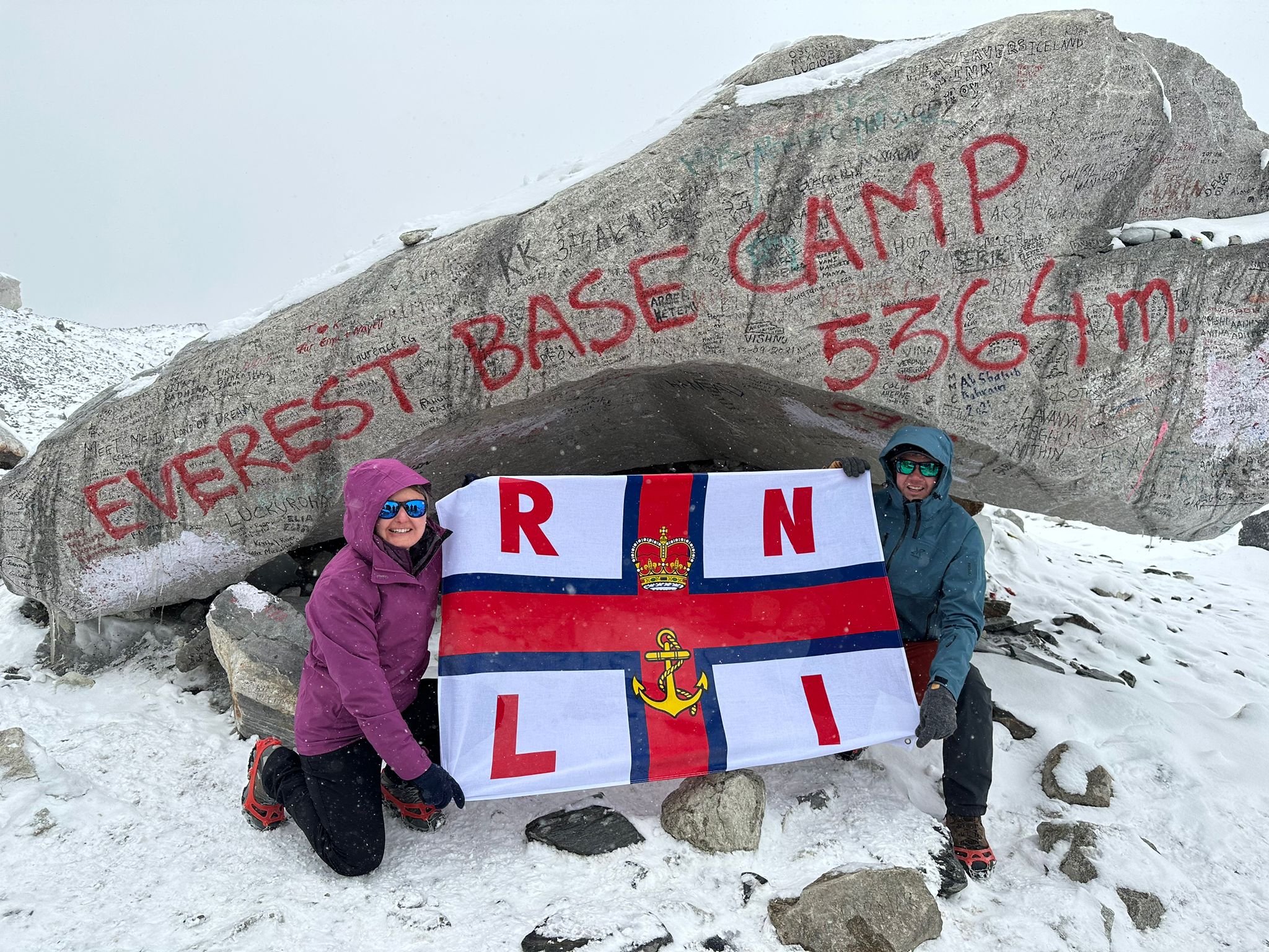 Amy and Bleddyn at Everest base camp with RNLI flag