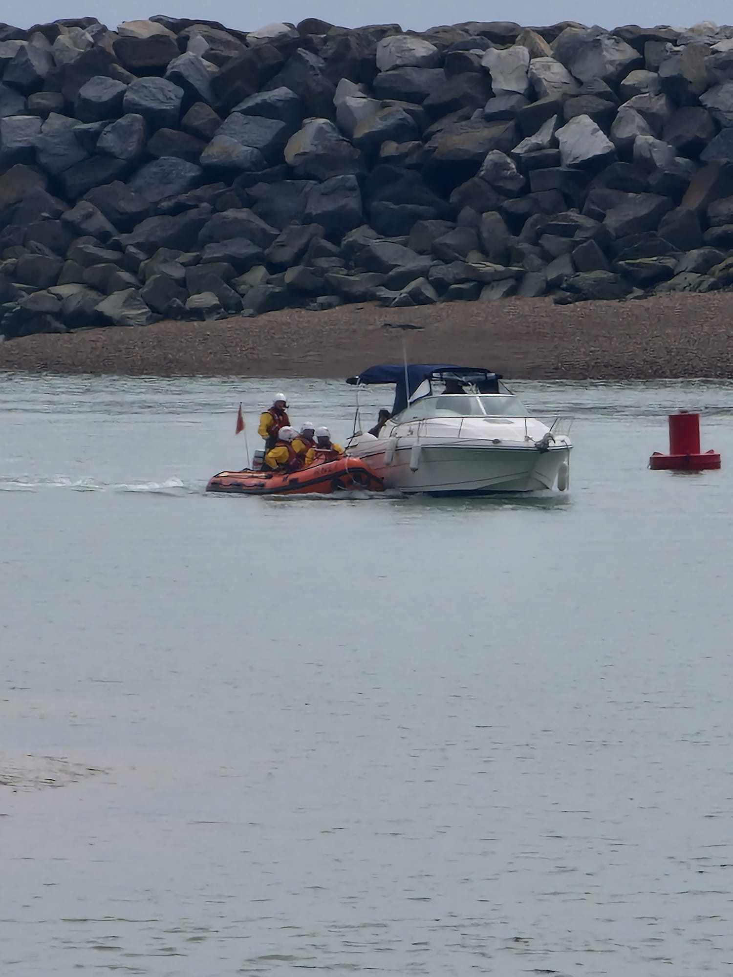 D class lifeboat and casualty vessel at entrance to harbour 
