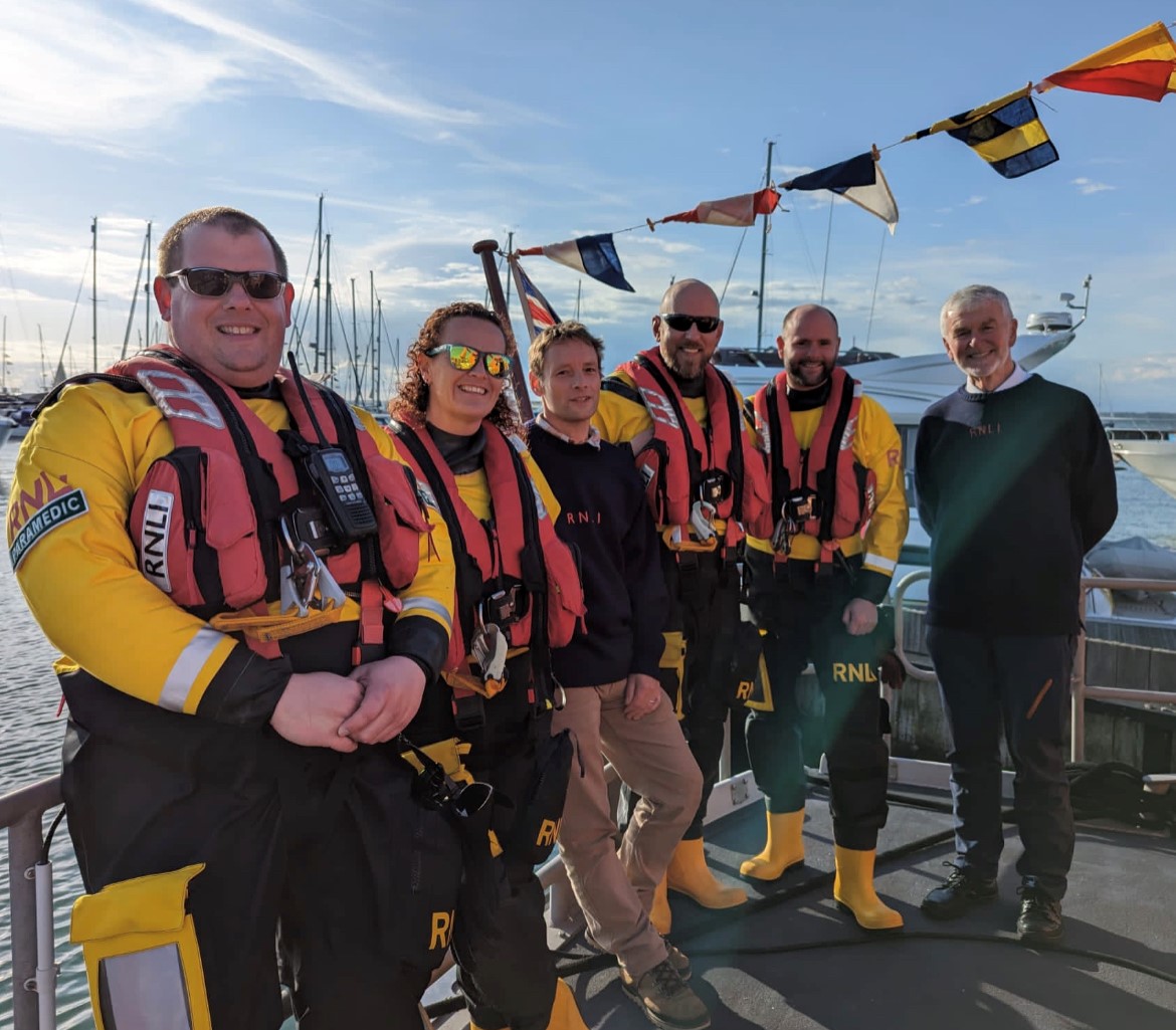 Photo showing six volunteers from the crew on the back of the lifeboat.
