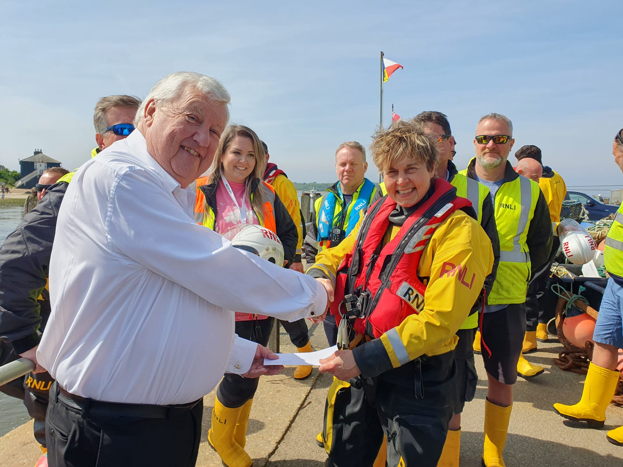 John Sellens handing cheque to RNLI boat crew volunteer Mel Varvel