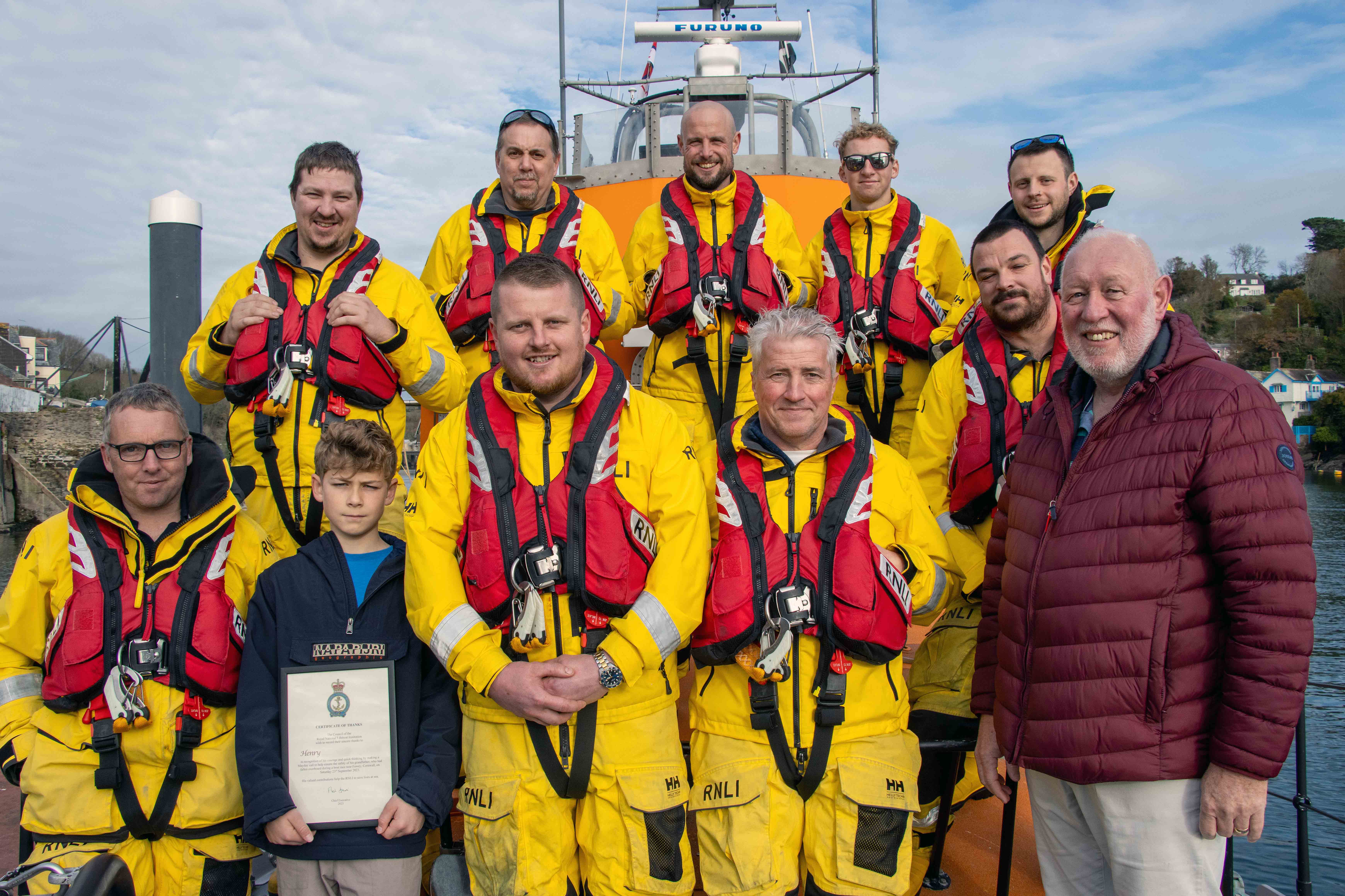 Henry, his grandfather and Fowey lifeboat crew pictured on the lifeboat