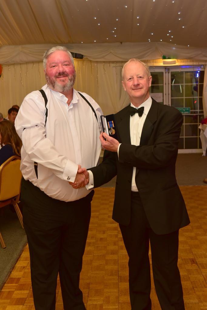 Lifeboat Operations Manager Matt Davies receives his 20 year medal from Adrian Carey