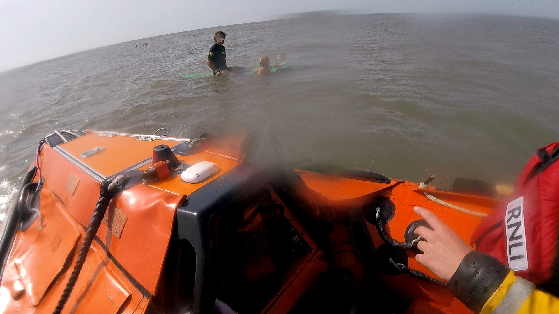 D Class crew approaching swimmers who were clinging to a surfer's board