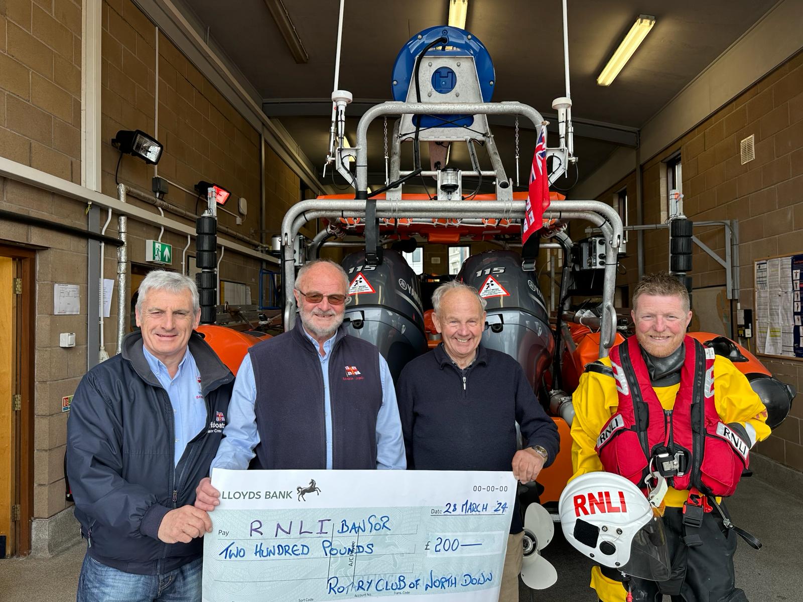 Bangor RNLI volunteers John Montgomery, John Magowan and Chris Beale receive a cheque from Peter Bullock