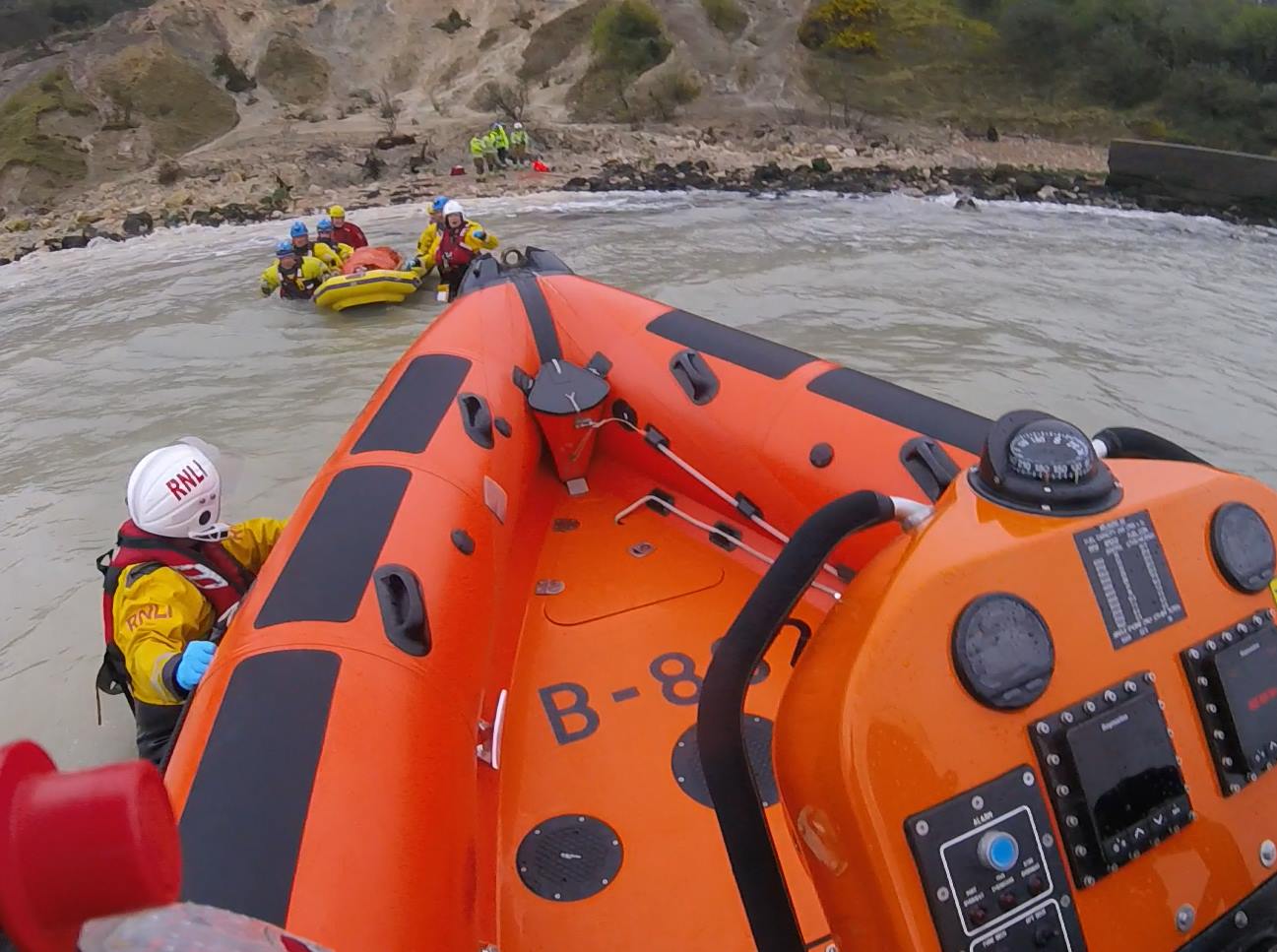The casualty carefully being carried out to the lifeboat on a stretcher