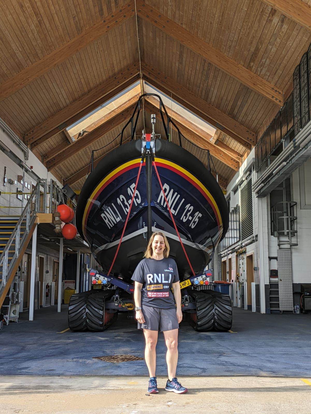 Woman standing in front of Scarborough RNLI lifeboat station with Shannon Class lifeboat