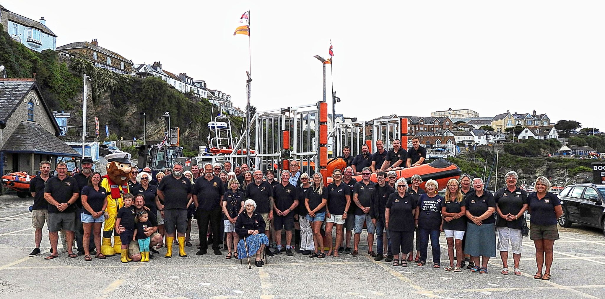 Newquay RNLI operational crew and supporting volunteers gather outside the lifeboat station to celebrate One Moment One Crew