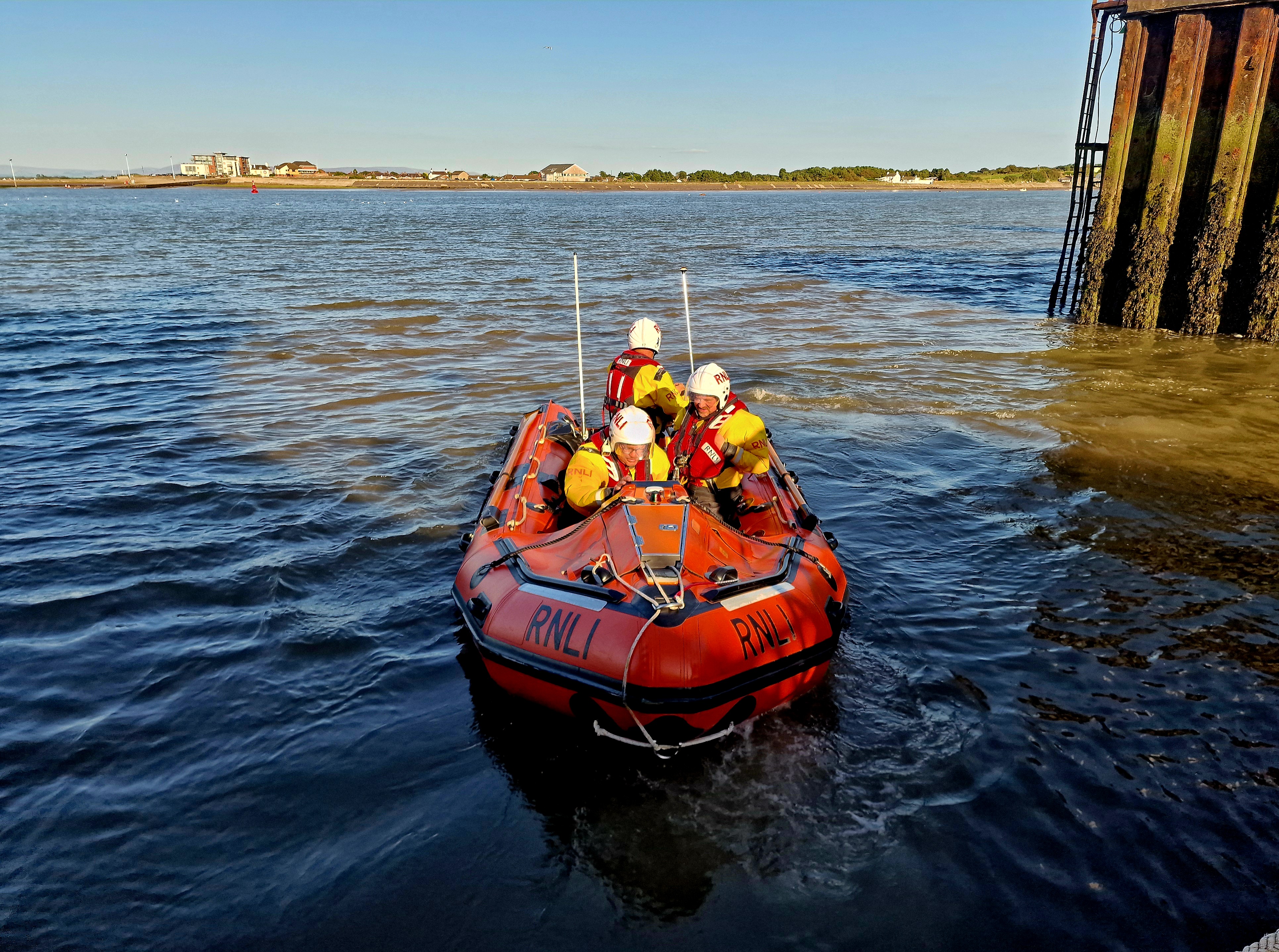 RNLI D Class lifeboat D-853 Harbet, launching on service. She faces the camera as she reverses out of the station's mooring pen,