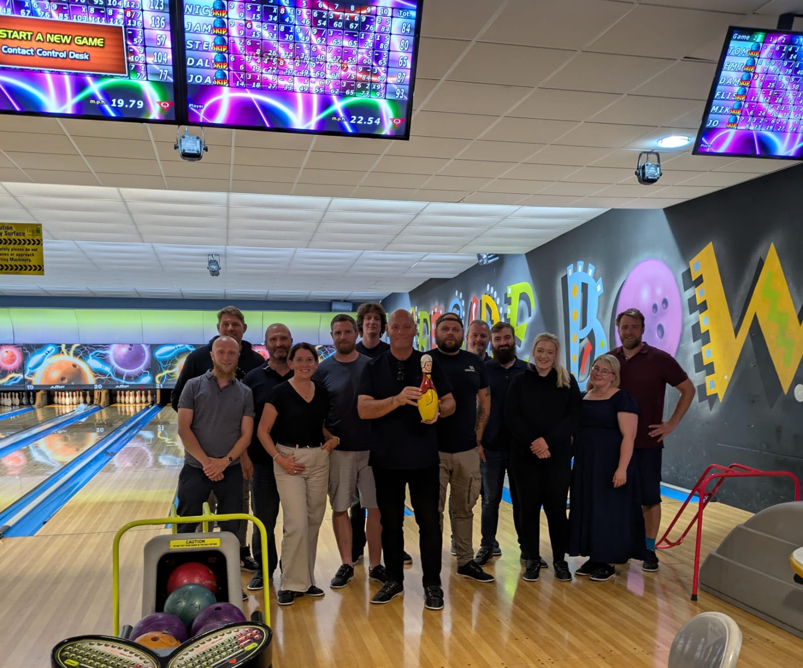 New Brighton RNLI's crew pose for a group photo stood on the bowling alley lane.

