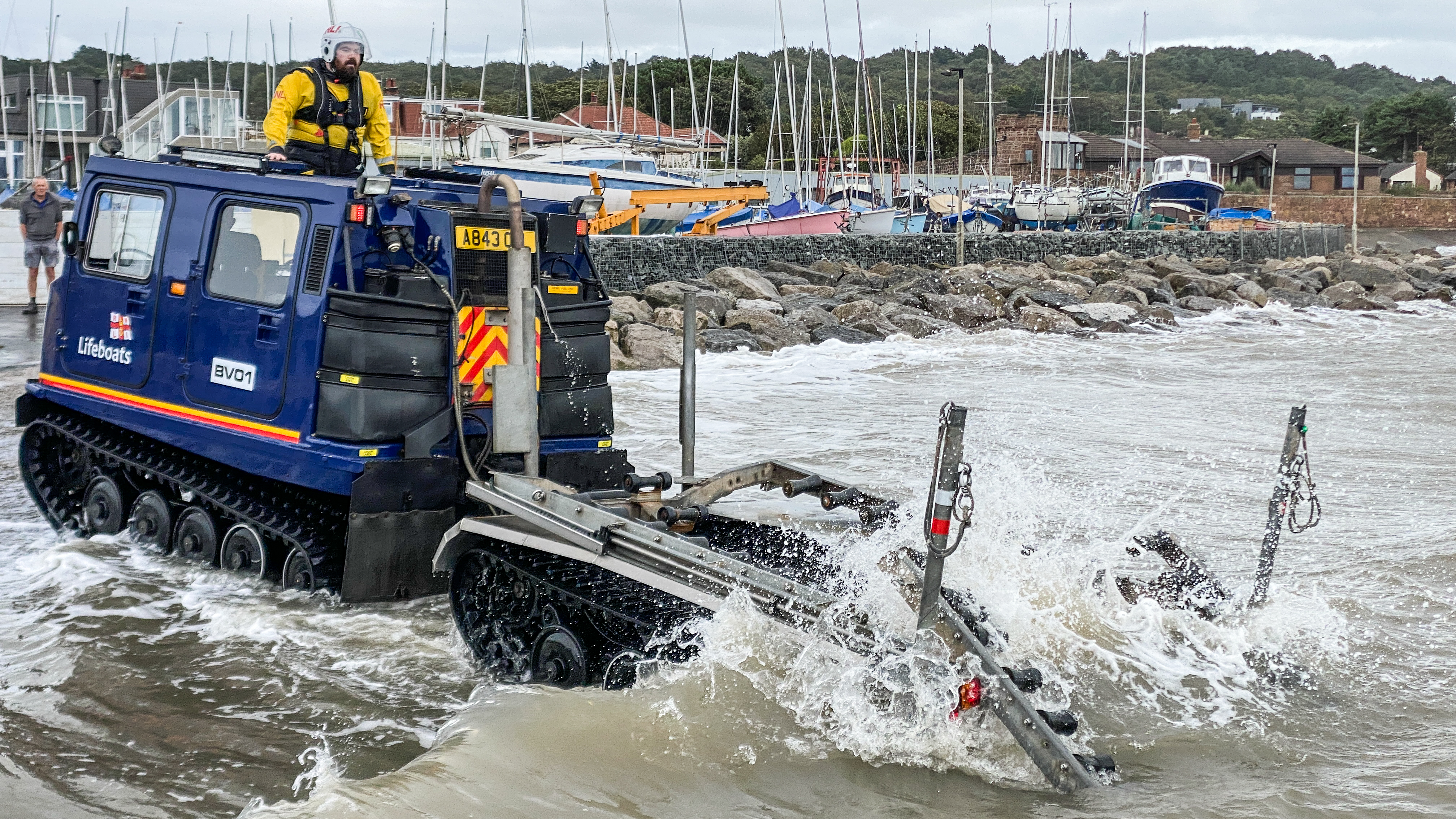 The Hagglund BV launch vehicle stands at the water's edge awaiting the D class lifeboat making its way in shore to re-join.