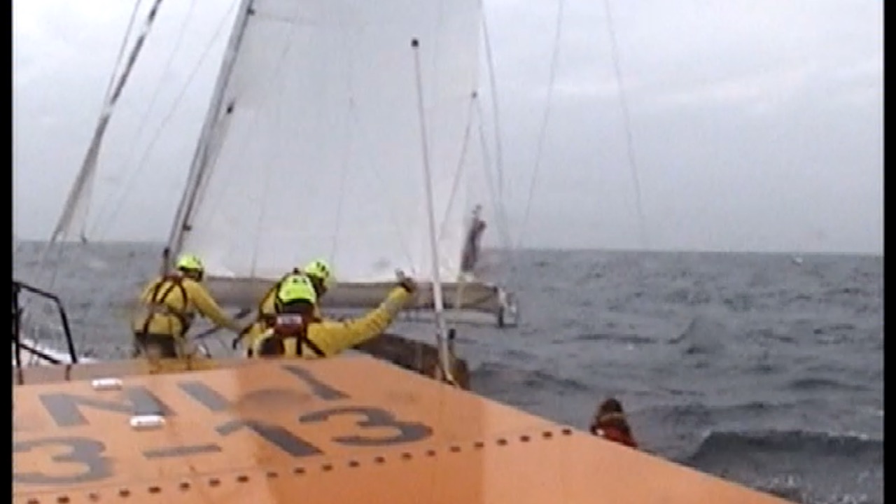 Swanage lifeboat crew volunteers being transferred to the yacht with the injured casualty