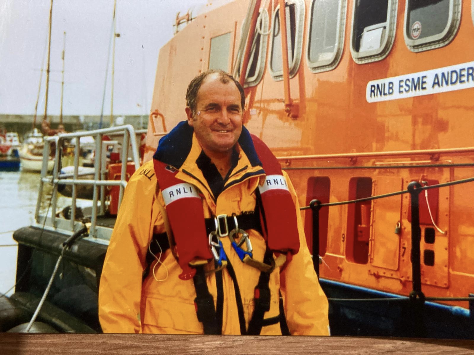 a lifeboatman stood besides a lifeboat