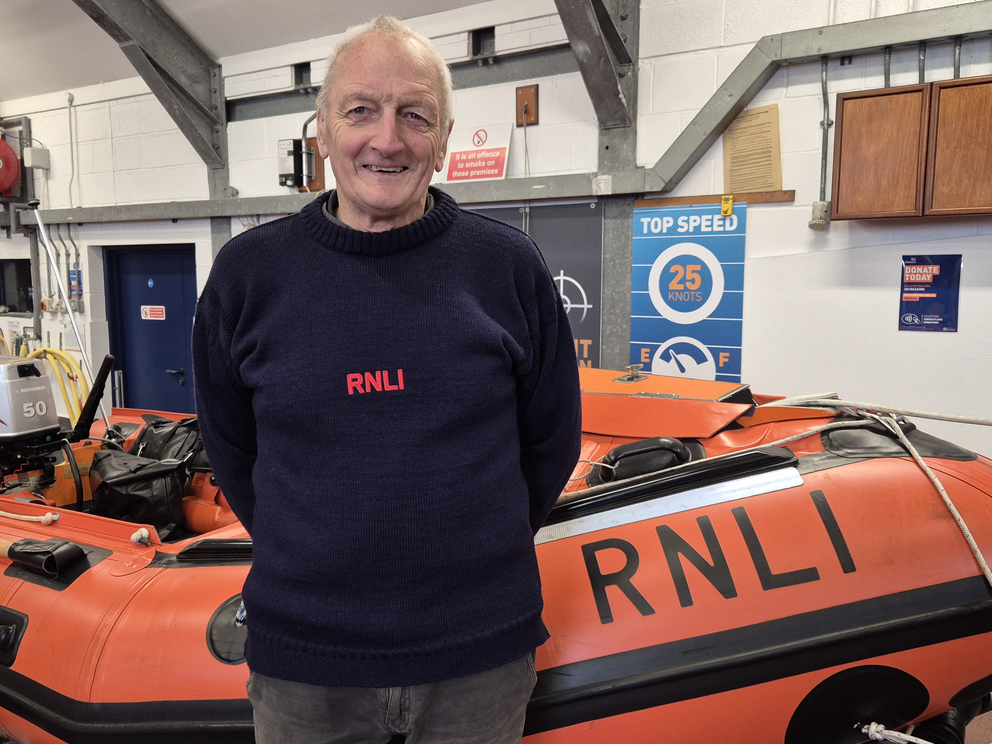 David Haines BEM stood in front of a D class inshore lifeboat