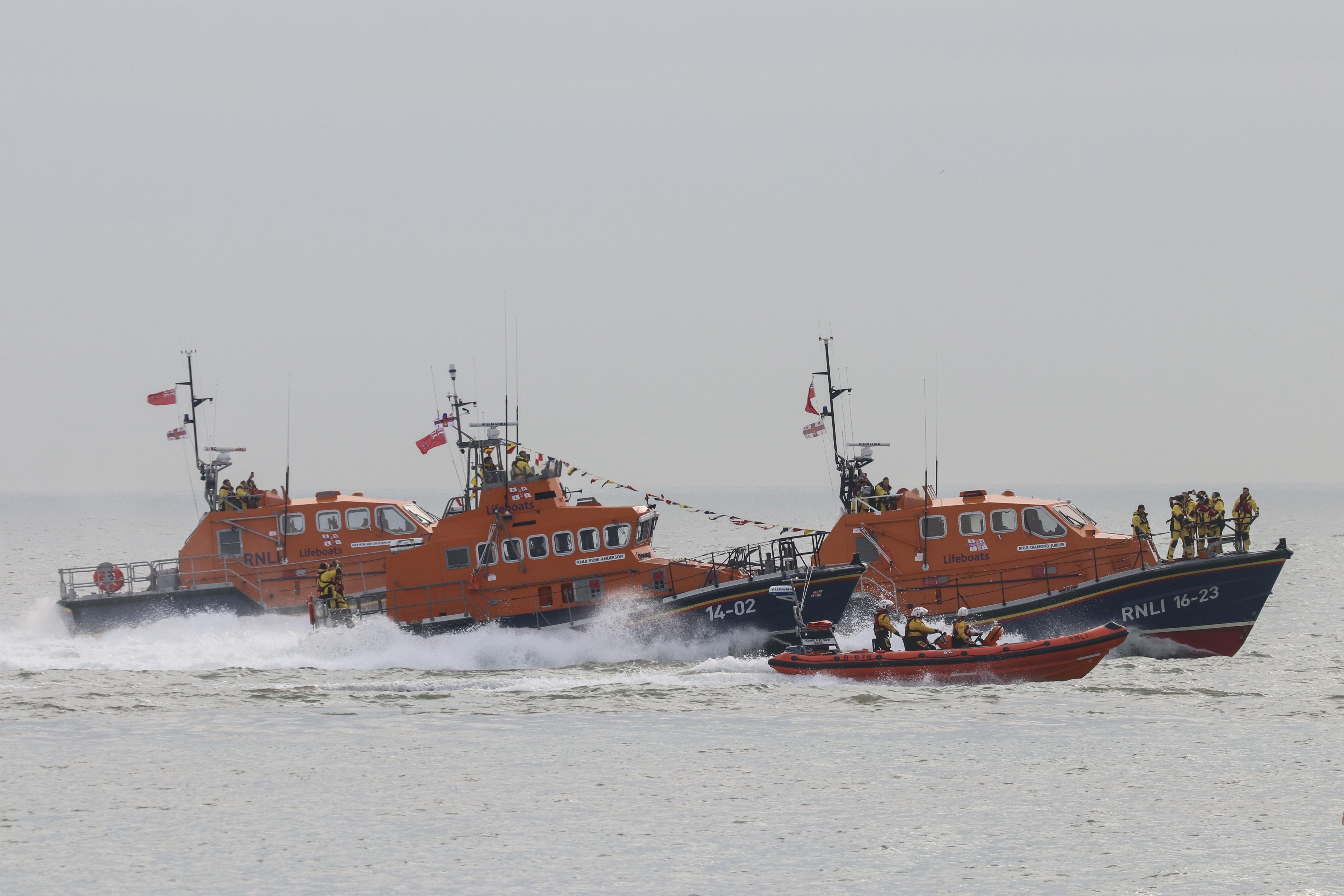 four lifeboats heading out to sea