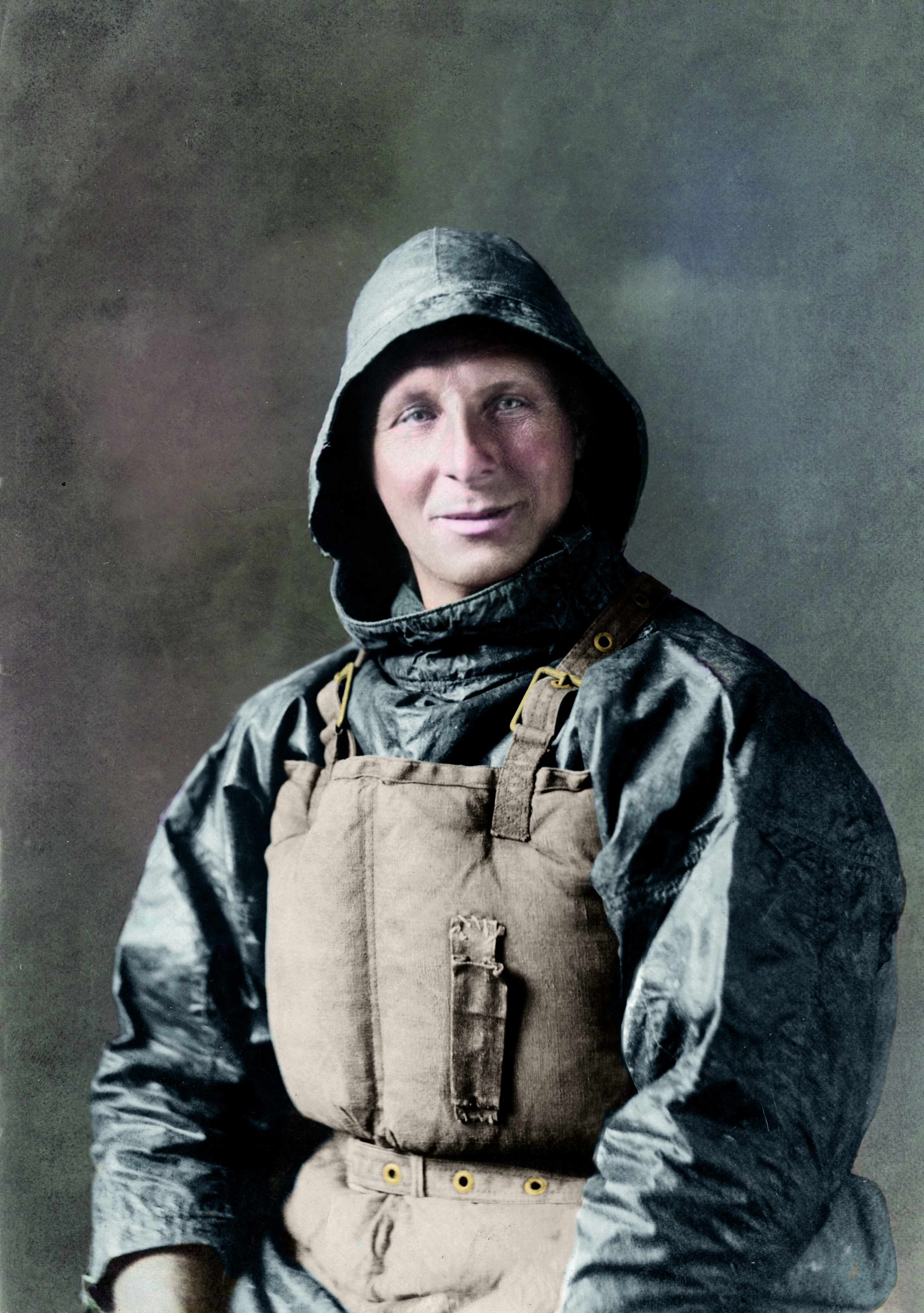 Portrait image of man in black oilskins and old lifejacket.