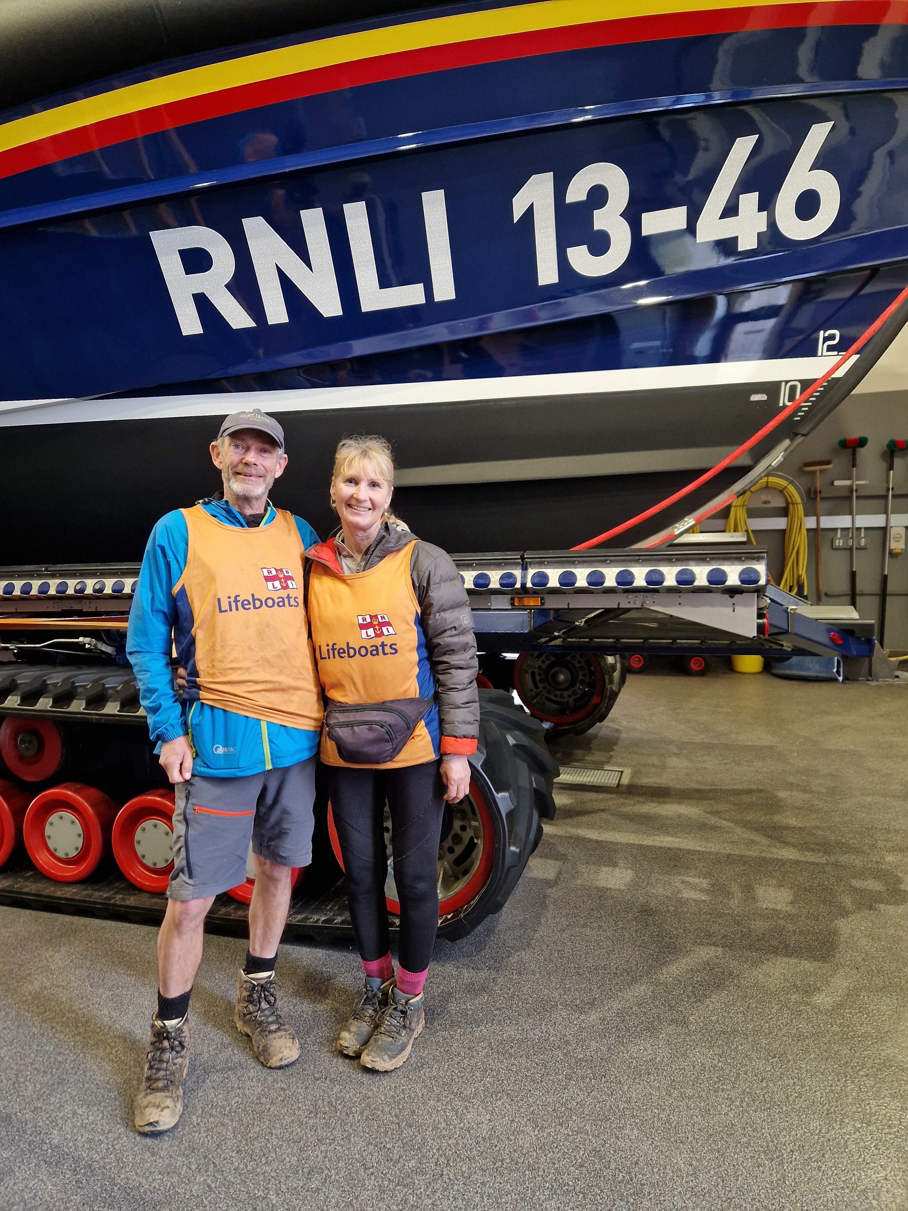 Man and lady standing in front of a Shannon all-weather class lifeboat