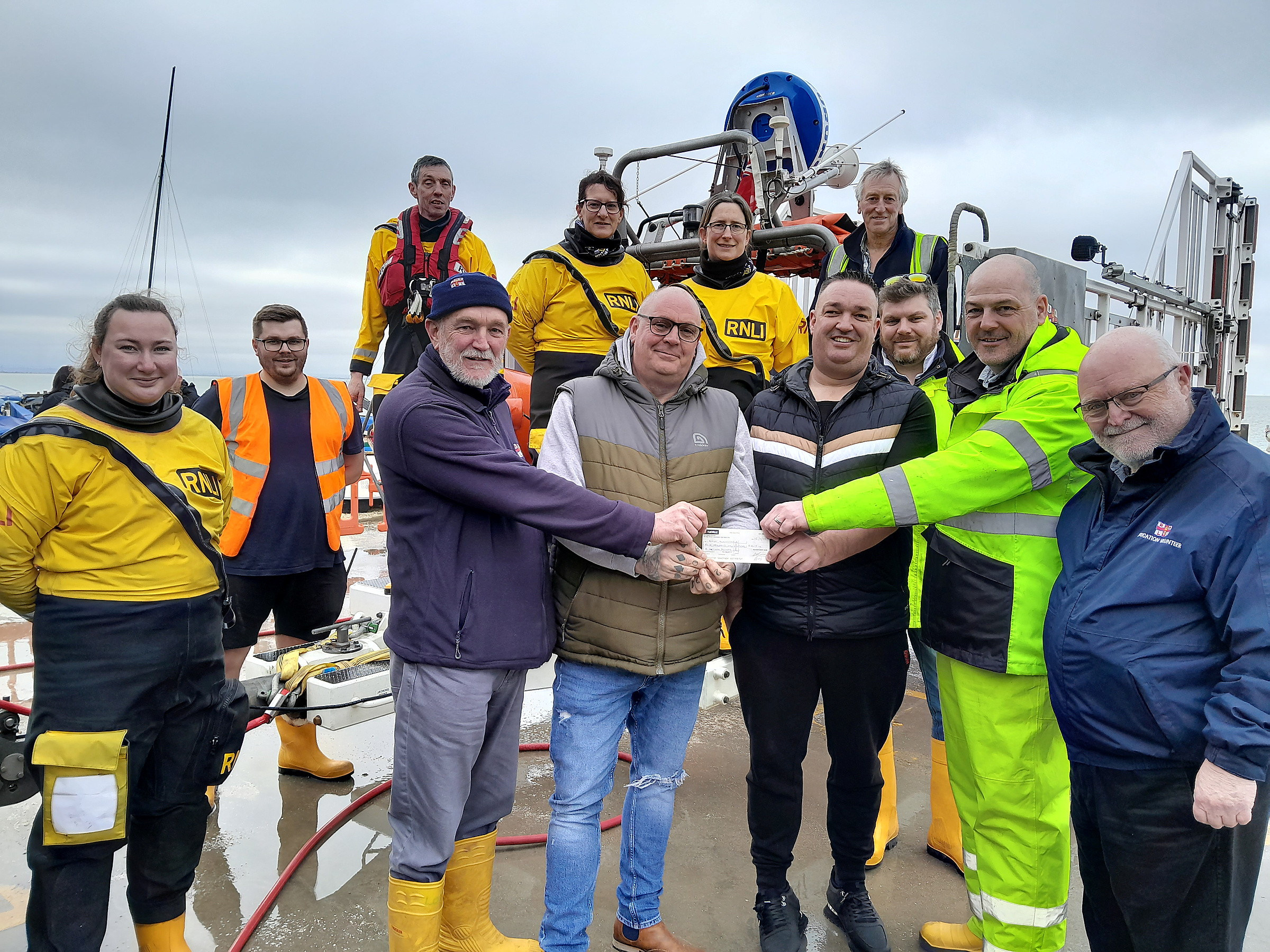 Paul Dayman and Terry Downes of the former Seaview Boat Club present the cheque for £4115 to Lifeboat Operations Manager Mike Judge, left and Chair of Fundraising Pete Fenton watched by members of the crew and RNLI Education Volunteer Gerry Skinner, right, on Sunday morning. 