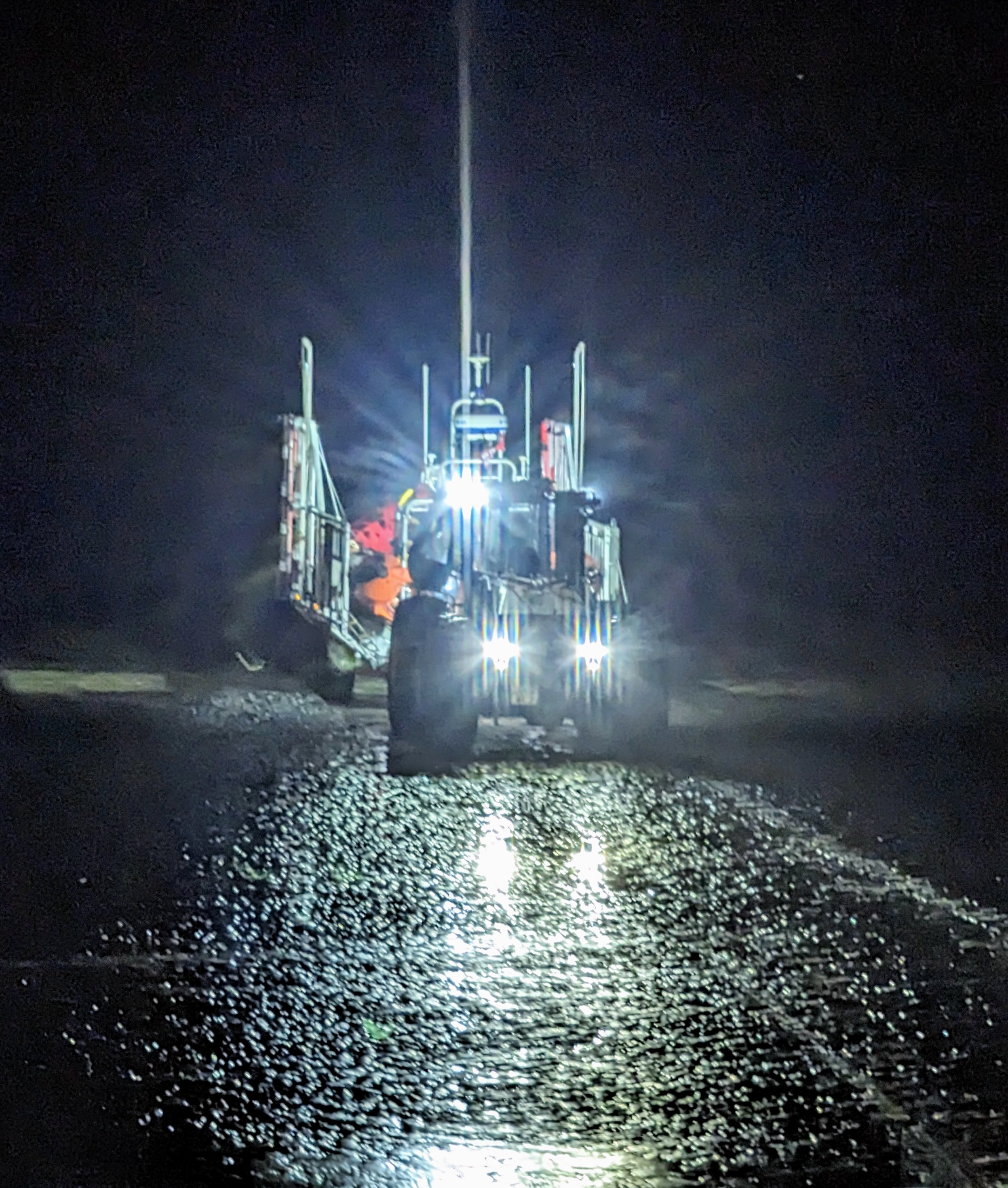 A large RNLI tractor brings the lifeboat back to the station after a trip out to sea on a dark cold night