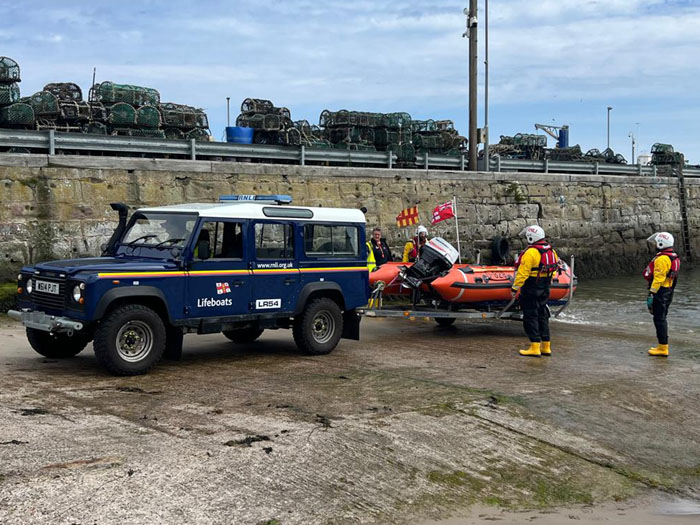 Two people and a dog in campervan cut off by tide on Holy Island ...