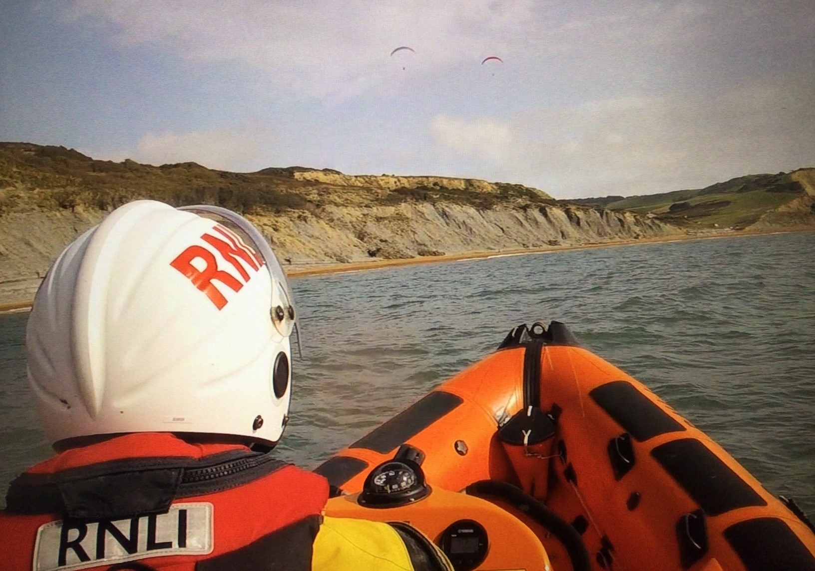 Phot shows Lyme Regis RNLI inshore lifeboat Spirit of Loch Fyne searching the coast to the east of Lyme Regis